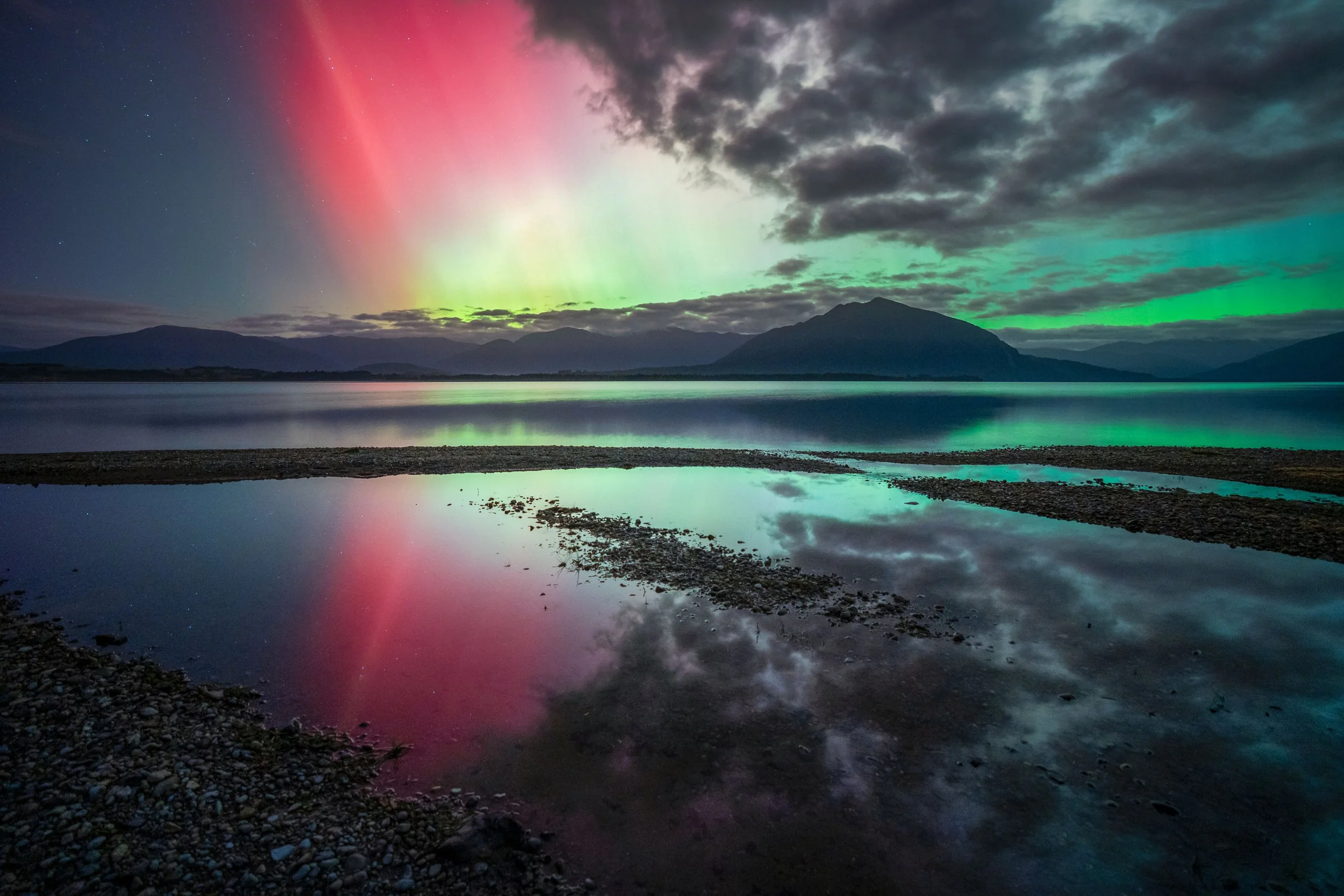 Aurora australis reflecting on the calm waters of Lake Brunner