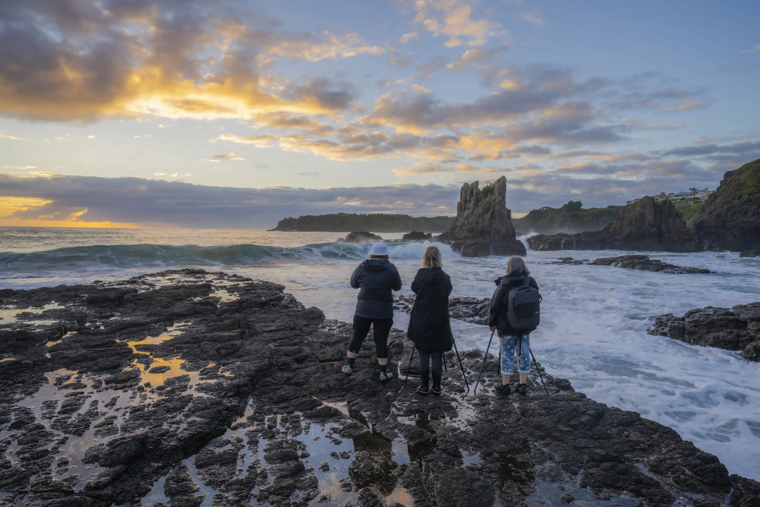 Photography workshop participants standing at Cathedral Rocks at sunrise