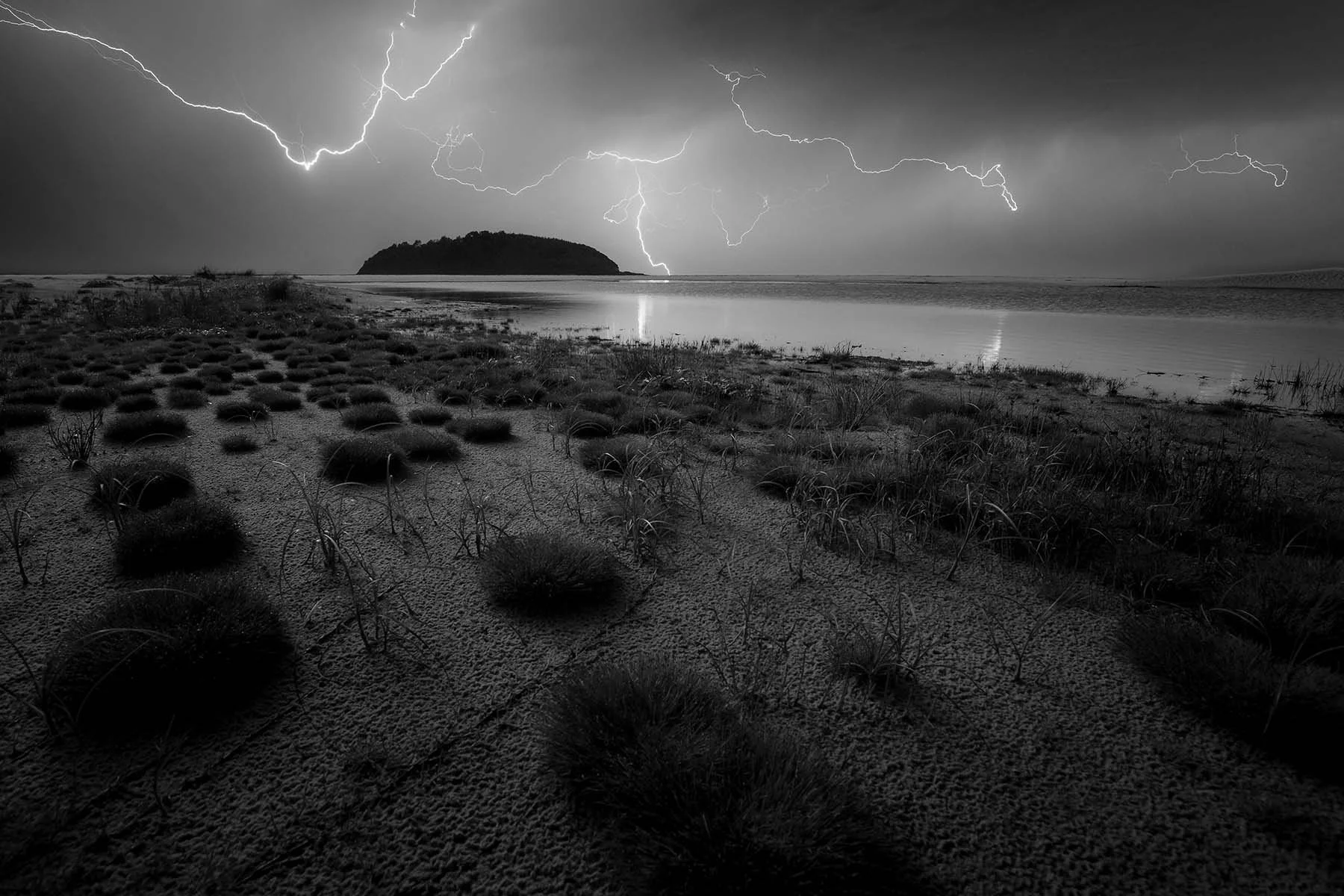 Stormy sky with lightning striking above Crampton Island, Lake Tabourie, NSW