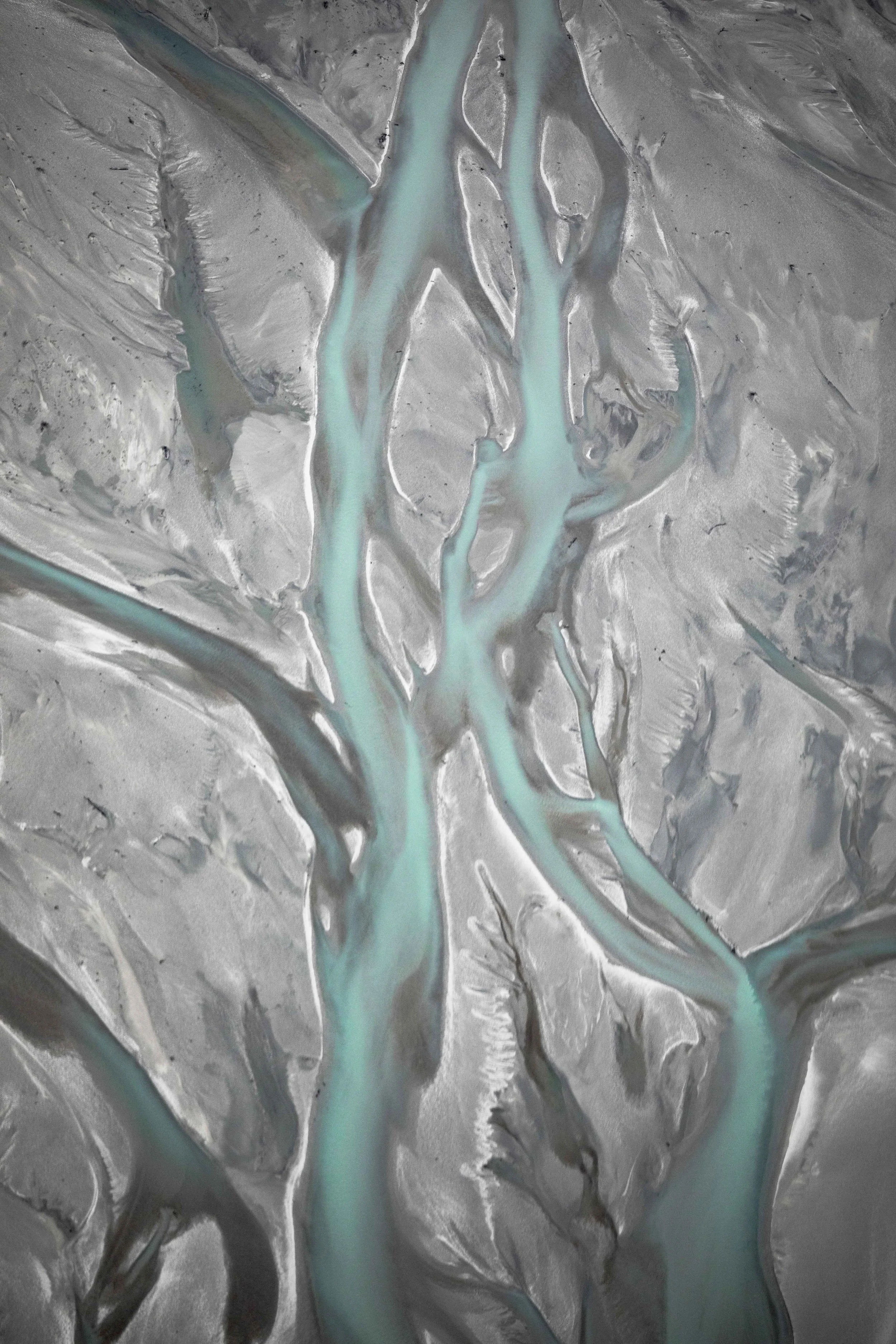 Glacier rivers creating winding patterns through the New Zealand landscape from above