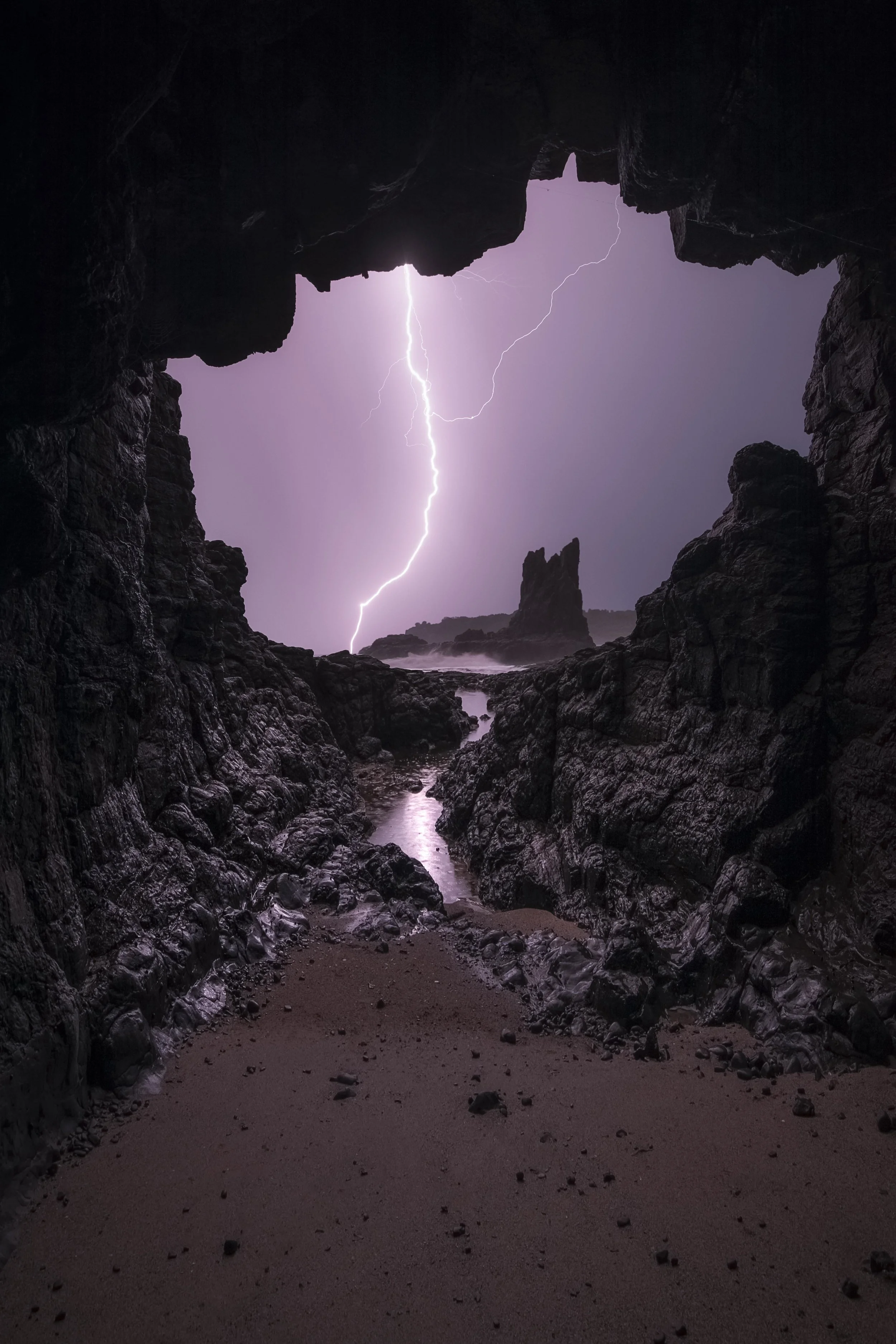 View from inside a cave at Cathedral Rocks looking out at lightning, Kiama, New South Wales