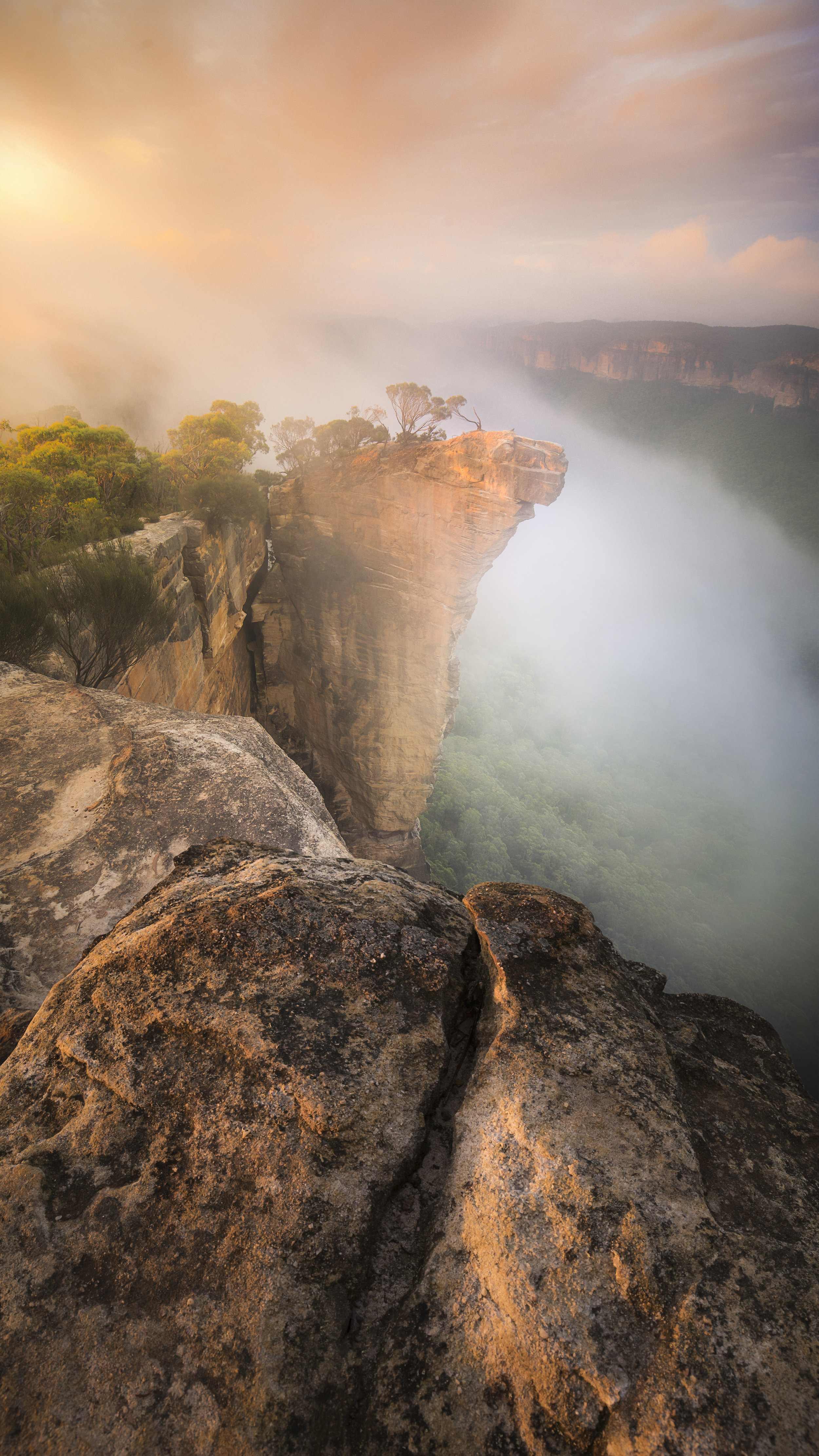 Hanging Rock shrouded in fog with surrounding cliffs and trees