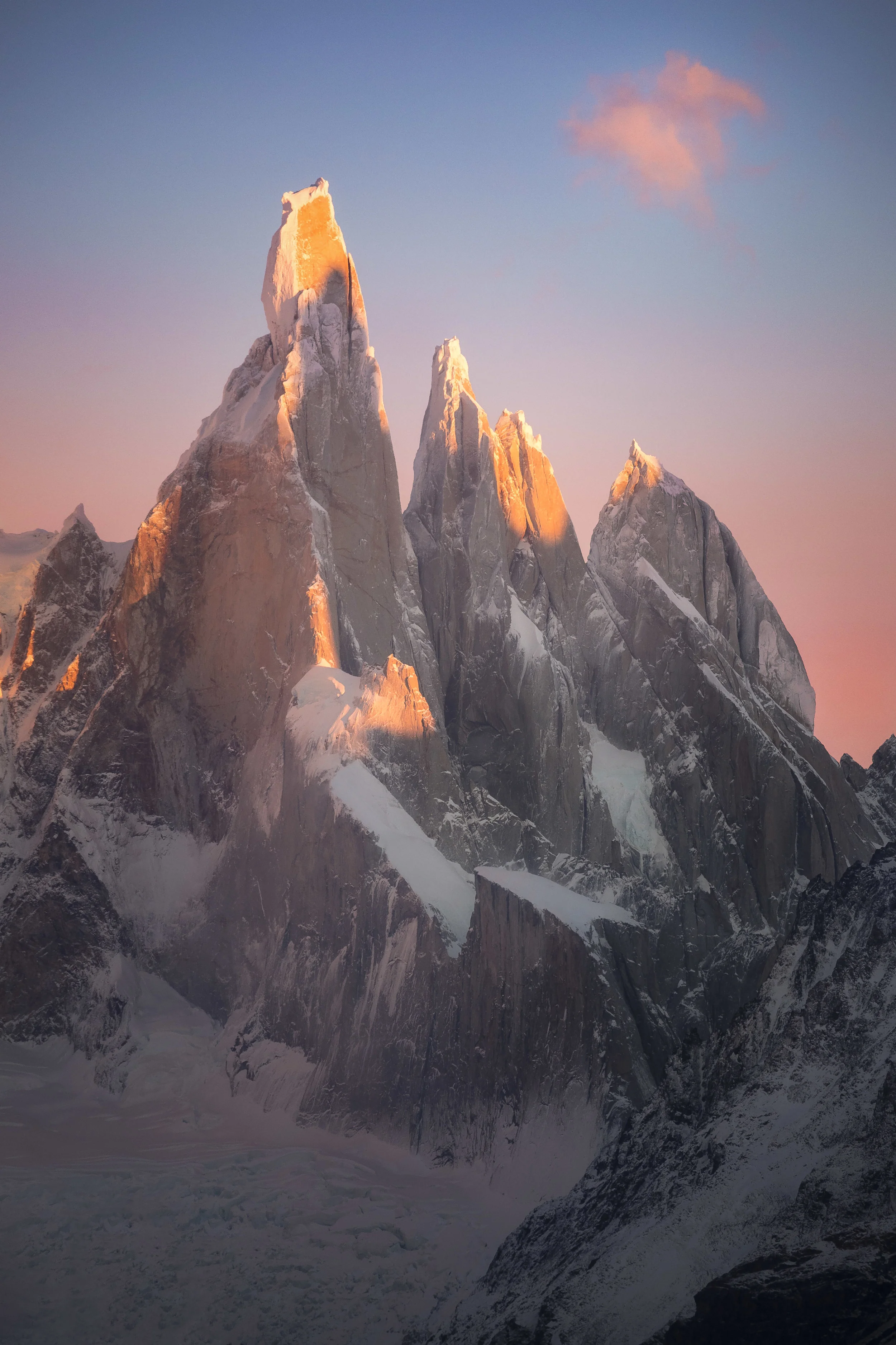 Cerro Torre in Patagonia at sunrise, with dramatic jagged peaks and warm morning light over snow and glaciers