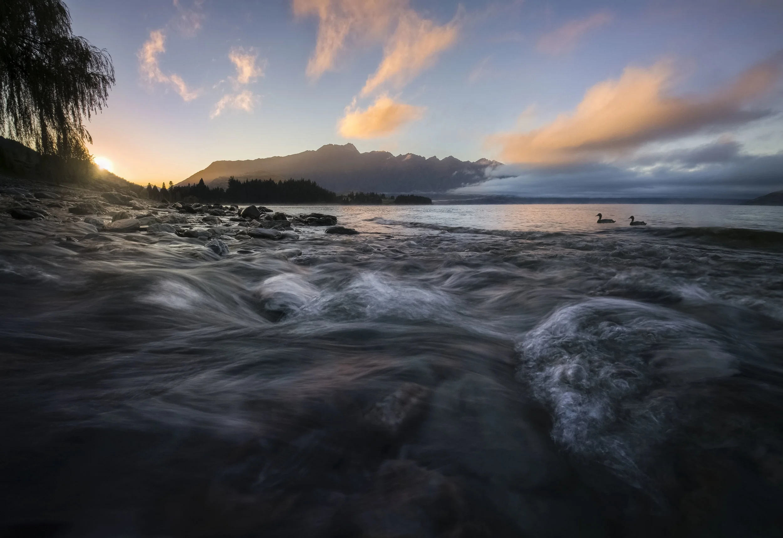 Early morning sunrise over the Remarkables near Queenstown, New Zealand, casting warm light on the rugged alpine peaks