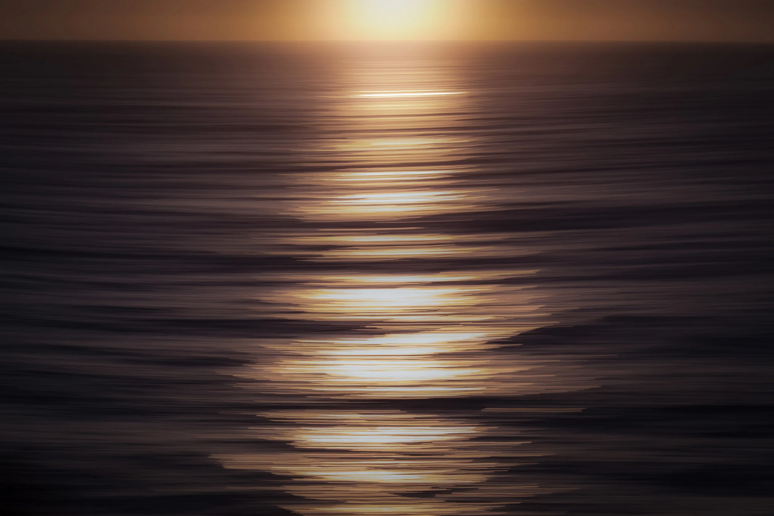 Blurred water reflecting sunrise light