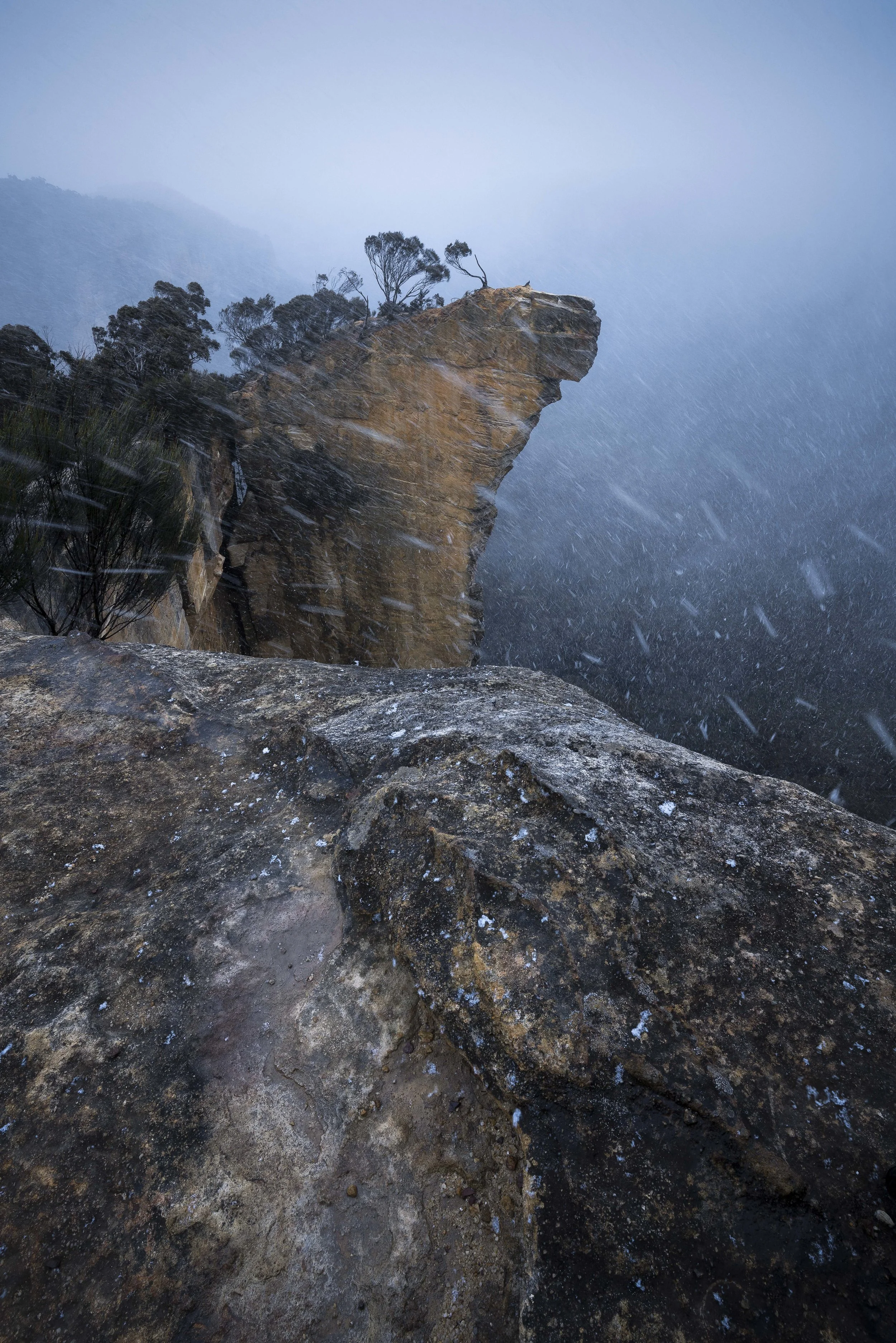 Hanging Rock in the Blue Mountains covered in snow, showcasing cliffs, trees, and a winter scene