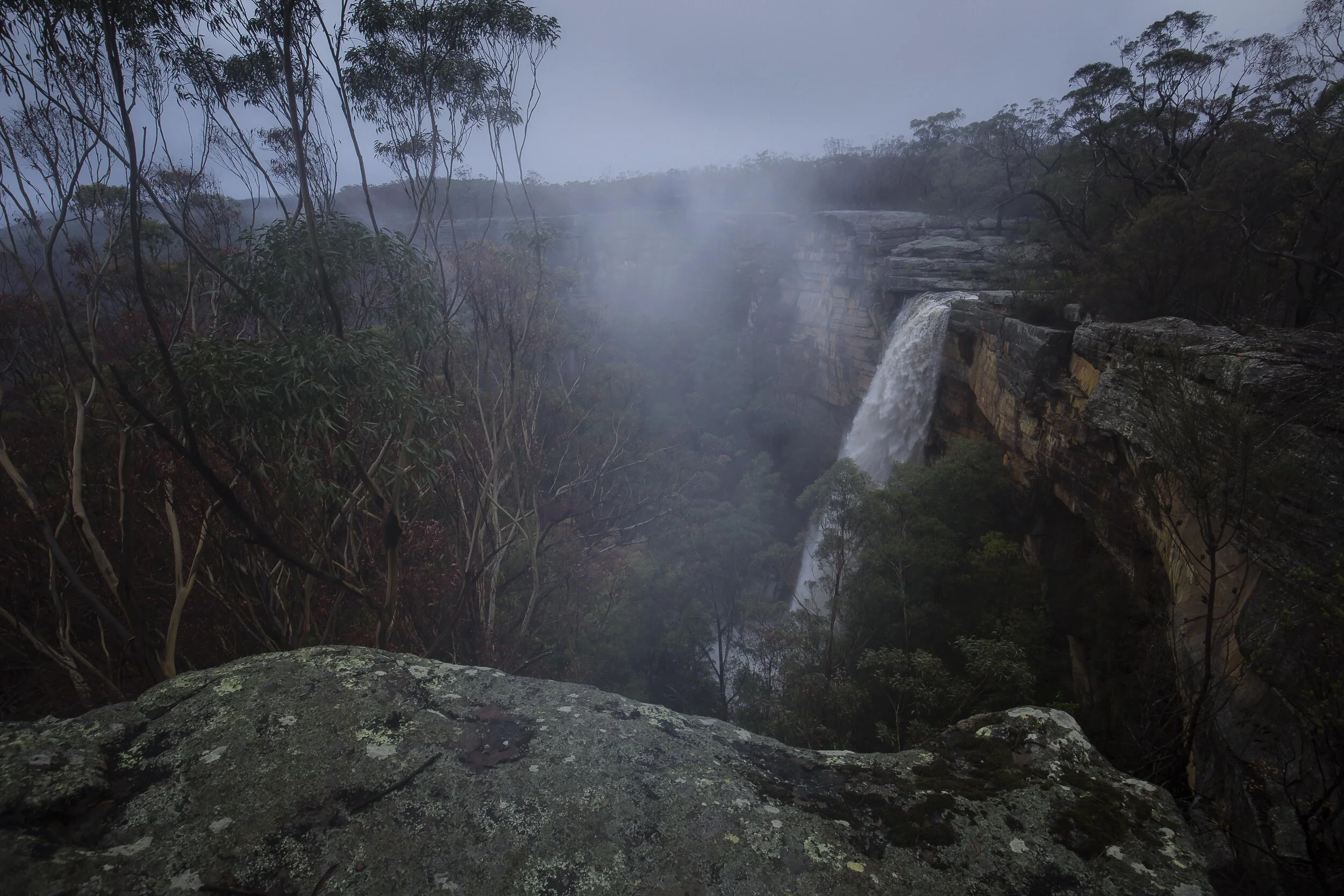 Raging Tianjara Falls with strong water flow surrounded by lush greenery