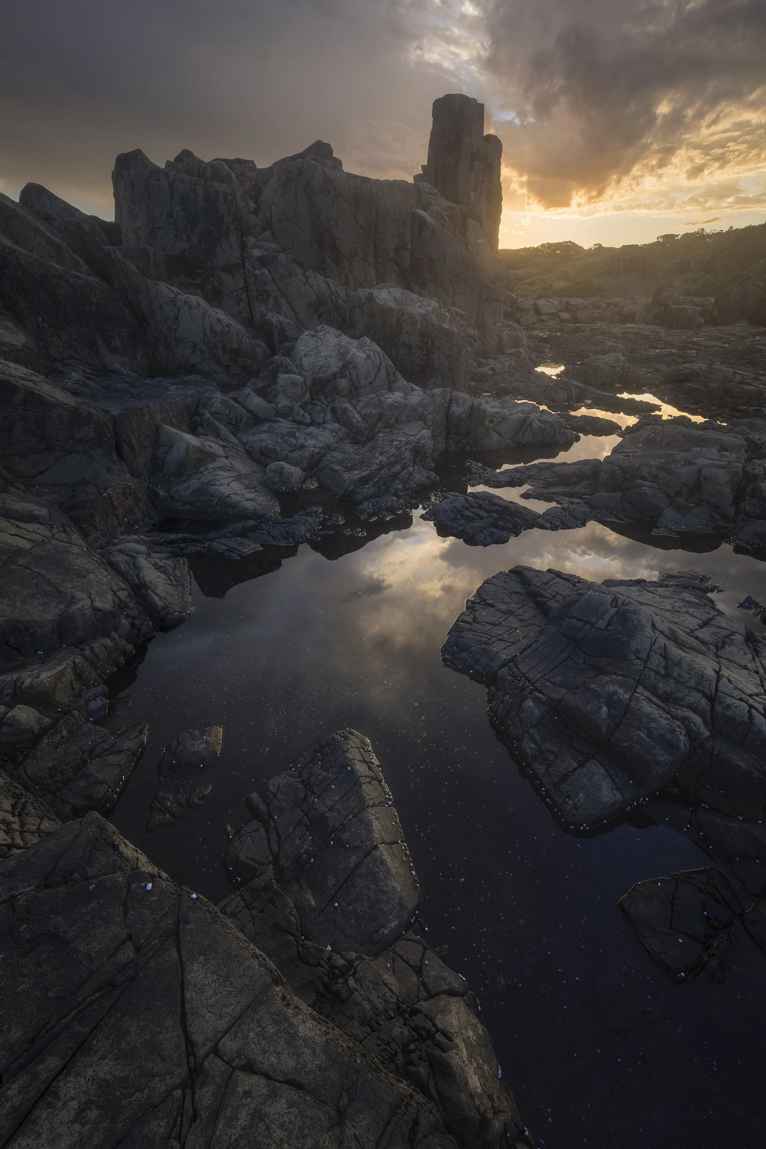 Golden sunset light illuminating the rock formations at Bombo Quarry