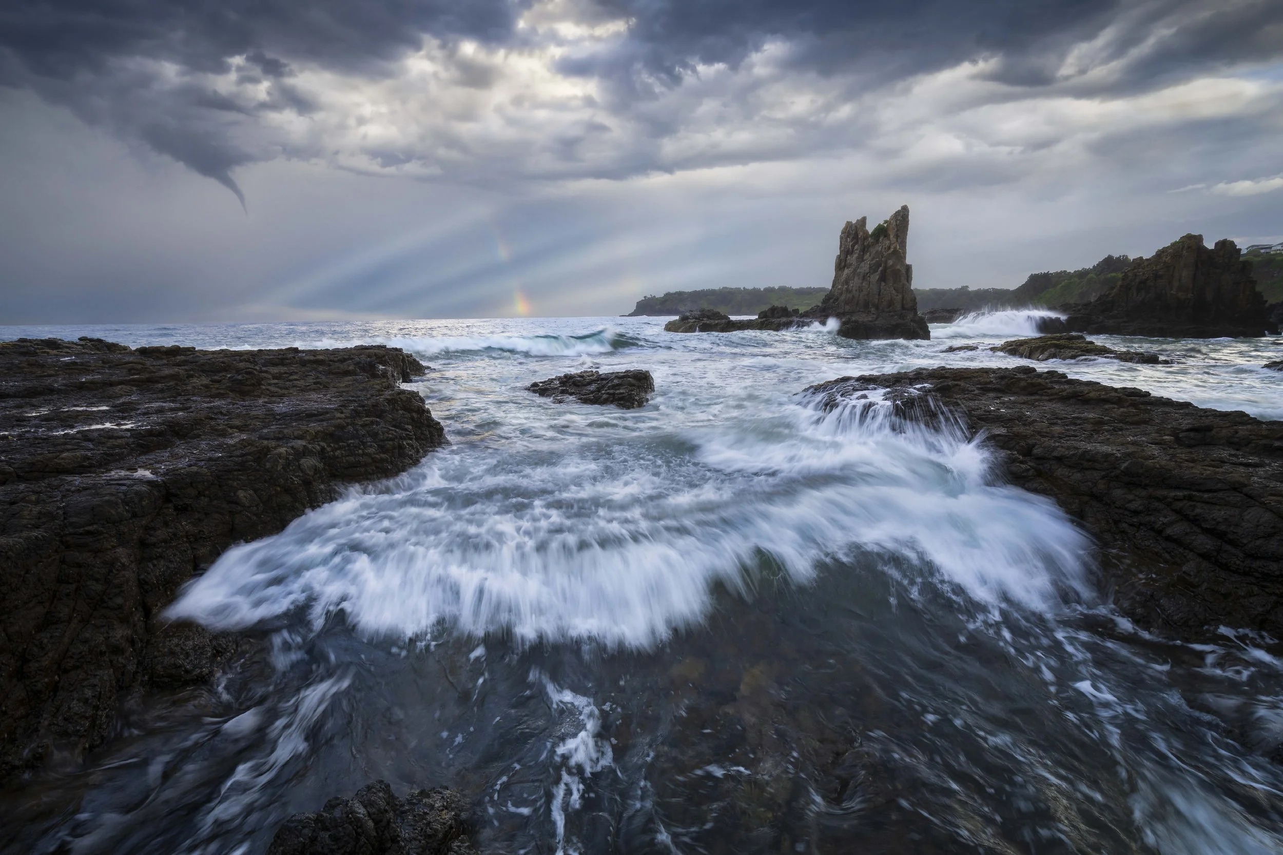 Sunlight beams casting light over Cathedral Rocks and the surrounding coastline