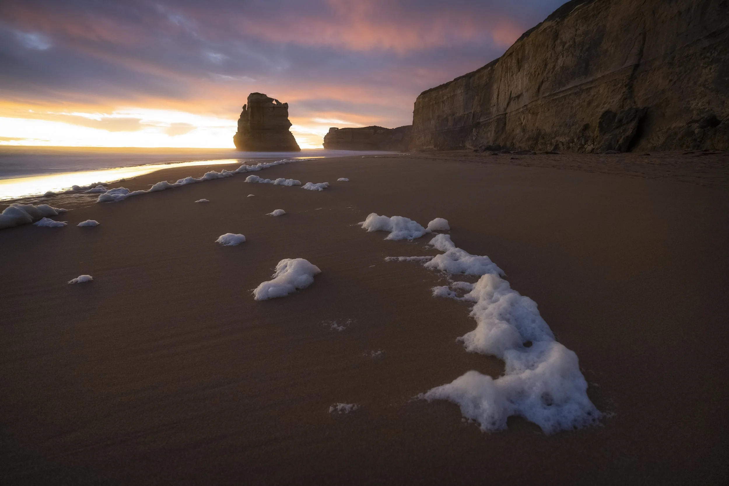 Sunset light illuminating the cliffs and sea foam at Gibson Steps