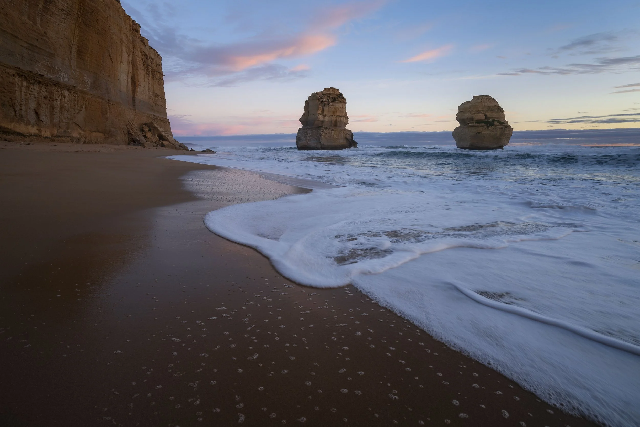 Waves crashing onto the sand beneath the limestone cliffs at Gibson Steps, Victoria