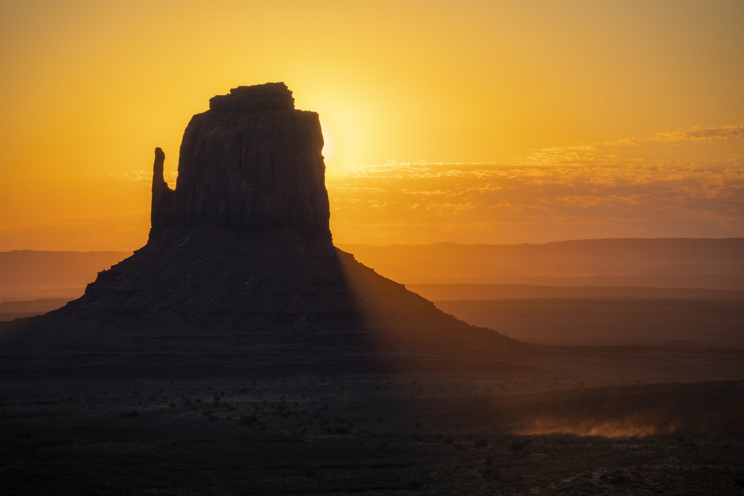 East Mitten Butte in Monument Valley at sunrise, highlighting the red sandstone cliffs and desert landscape