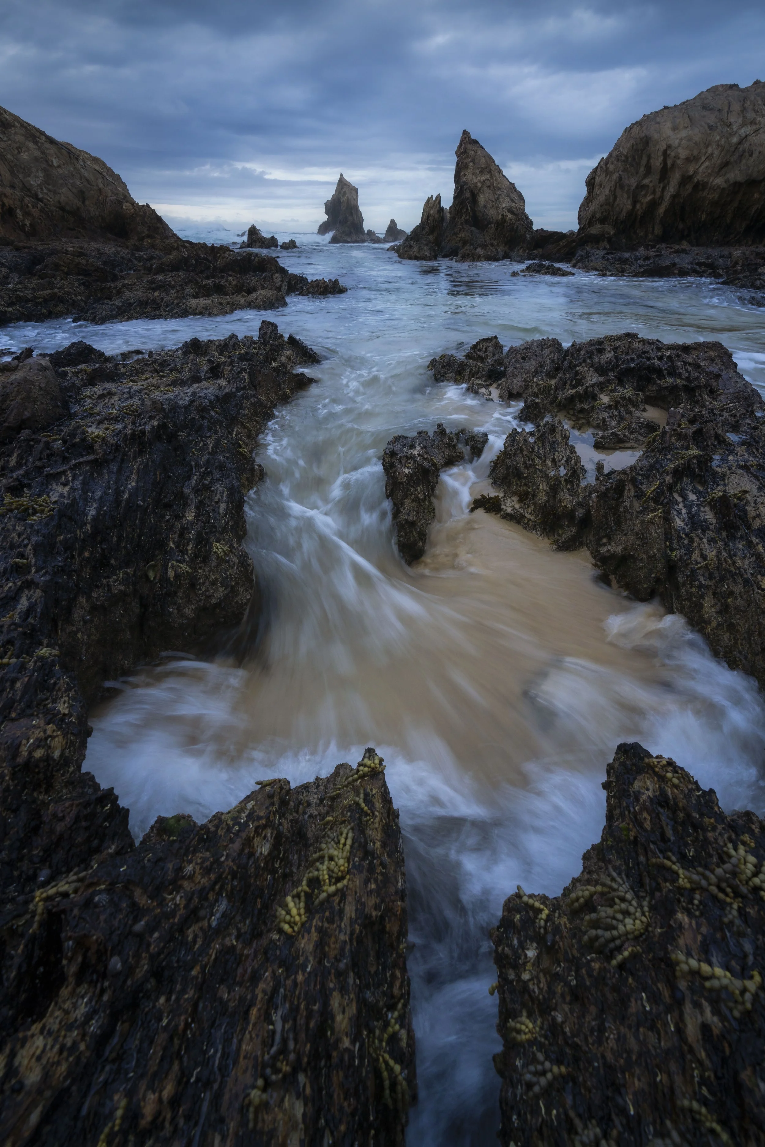 Long exposure of waves flowing around jagged rocks