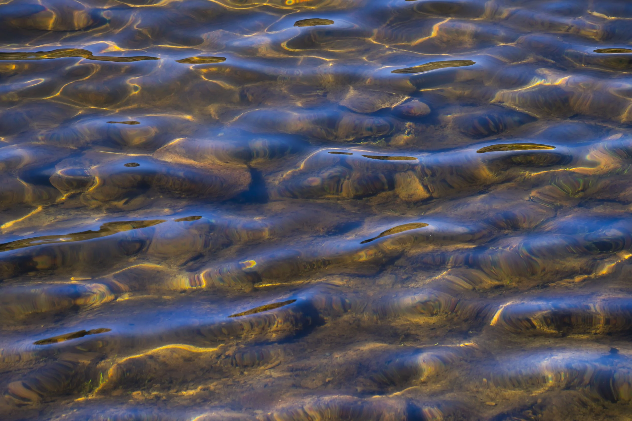 Water surface with ripples creating abstract reflections