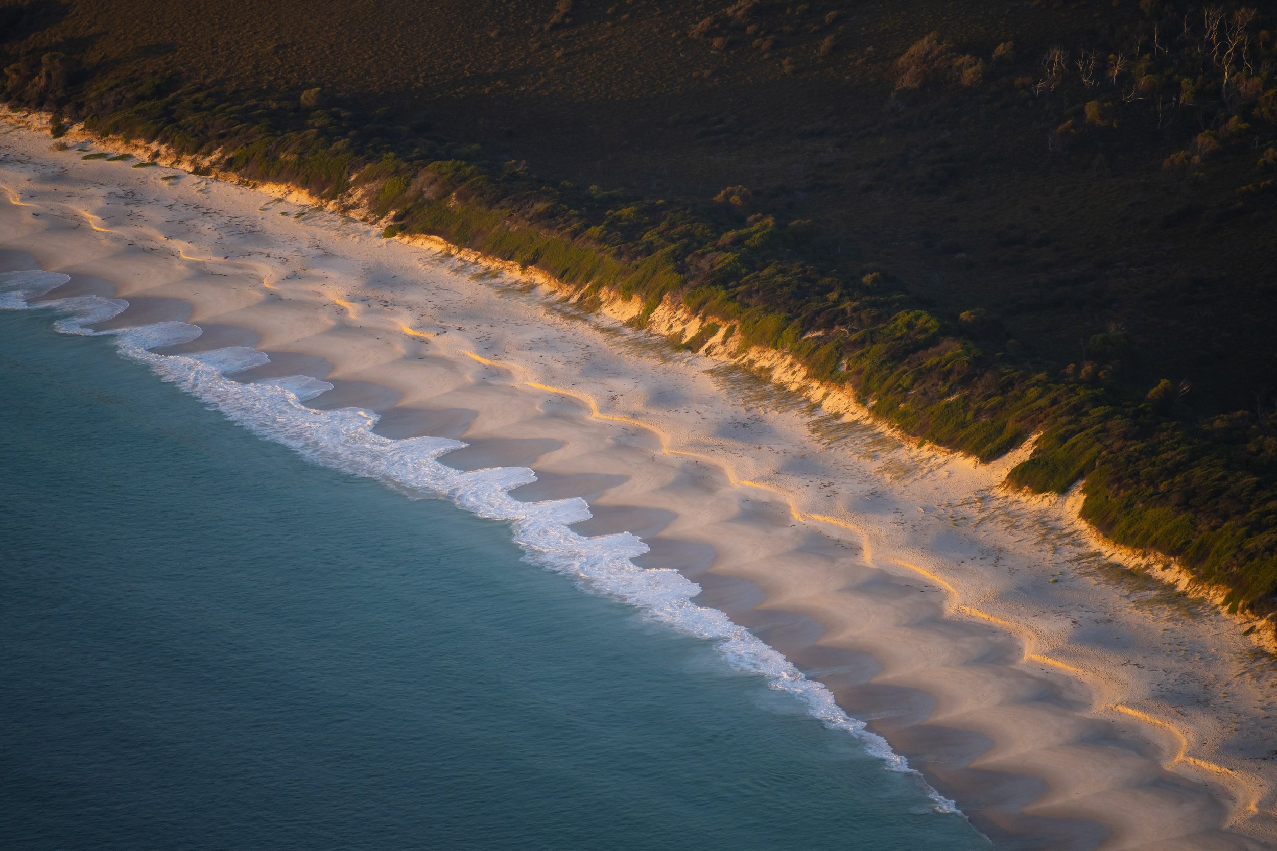 Aerial view of waves and sand textures along the shoreline