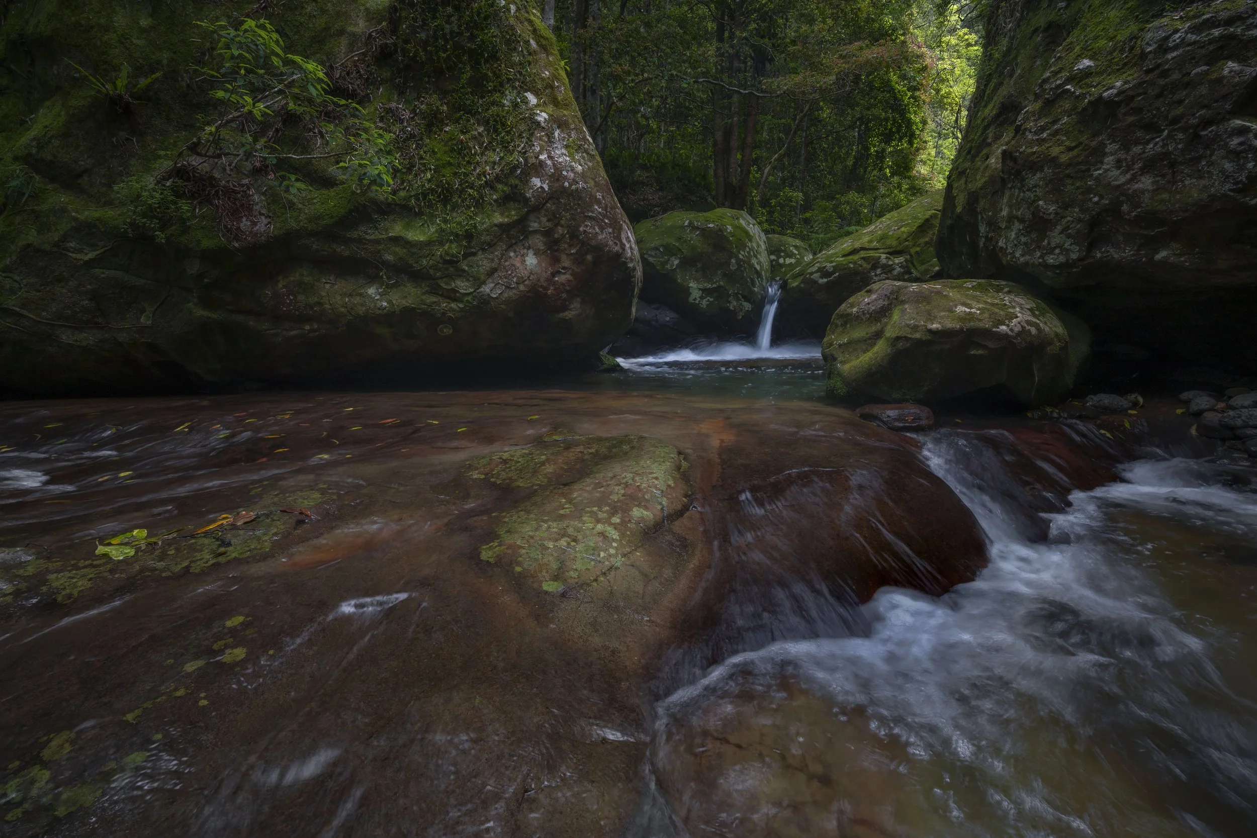 Cascading waterfall flowing over rocks into a serene pond