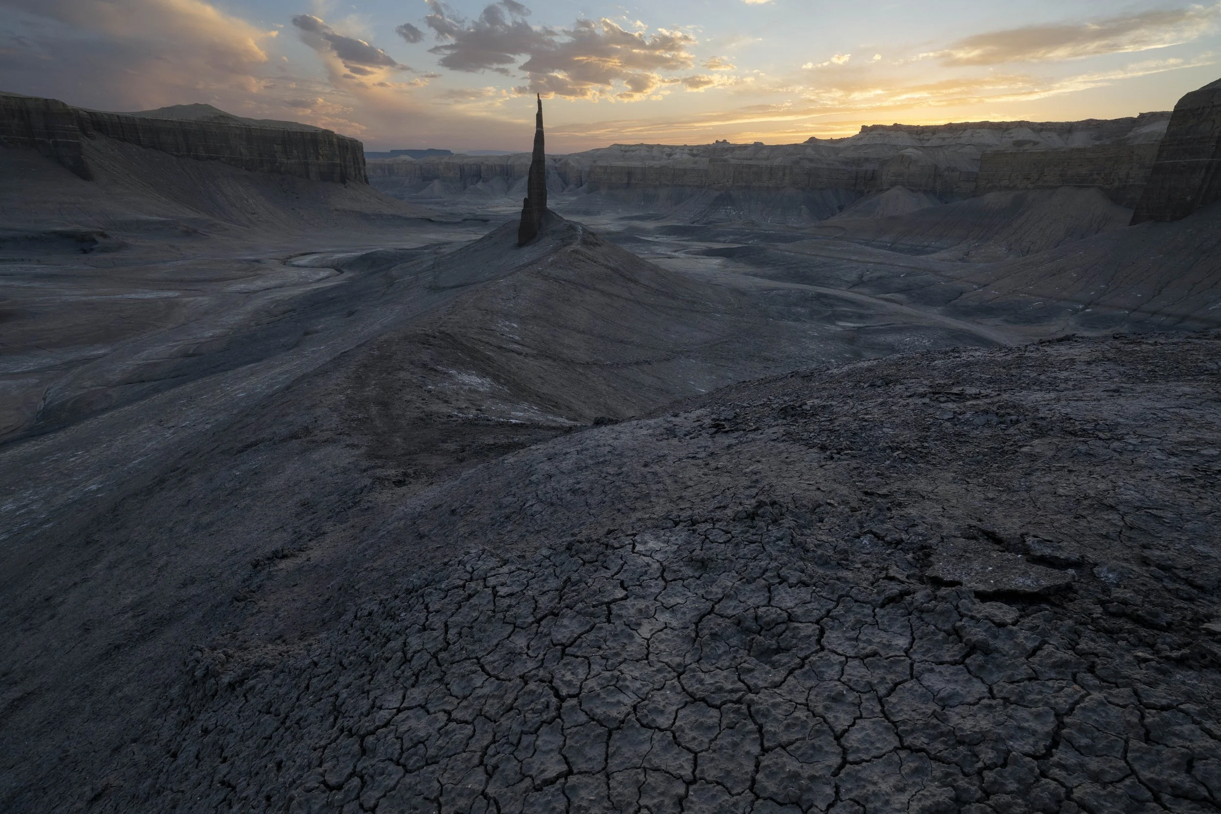 Sandstone rock spire near Hanksville, Utah, USA at sunset, highlighting desert terrain and glowing cliffs under a colorful sky