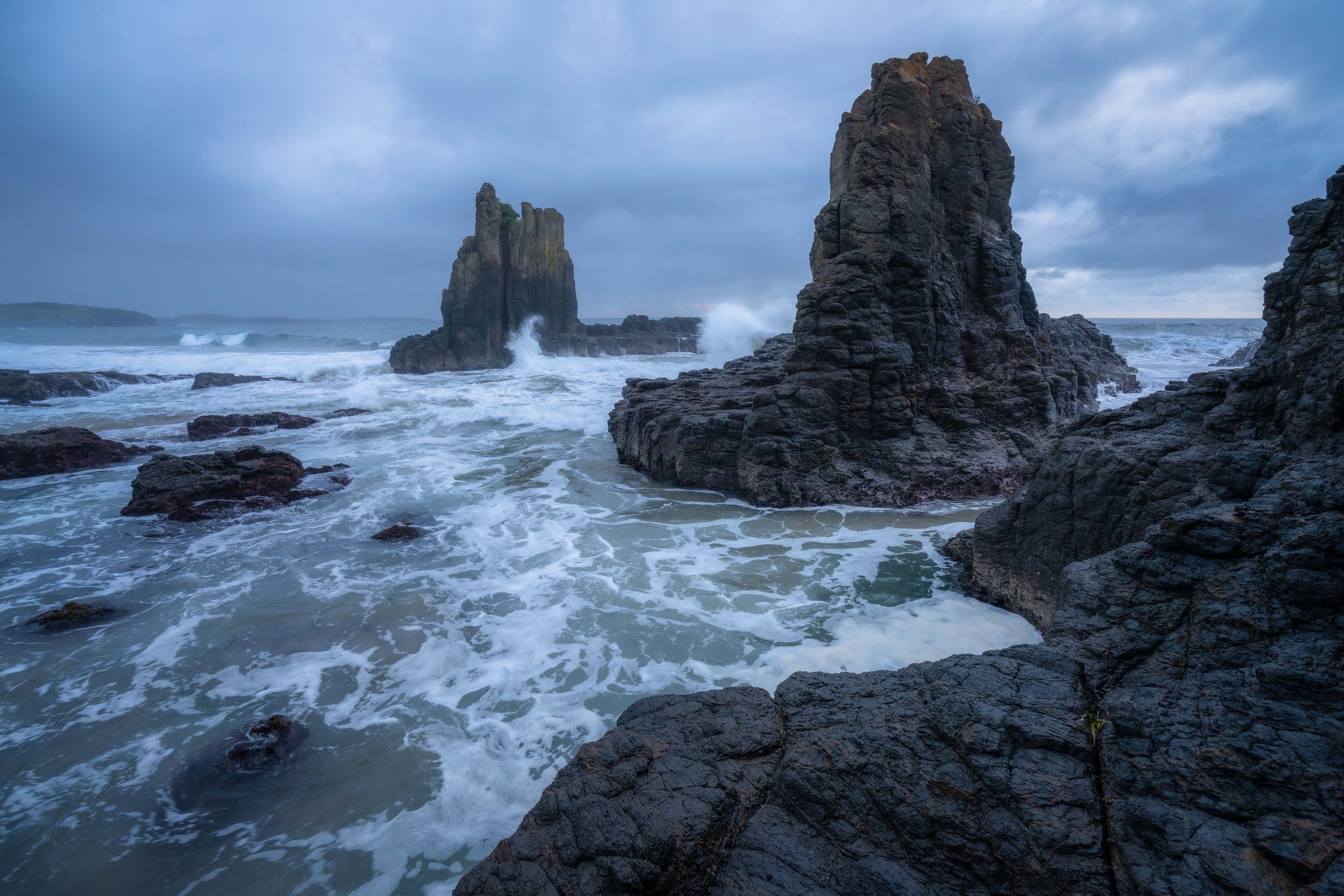 Rough sea with moody storm clouds at Cathedral Rocks, Kiama