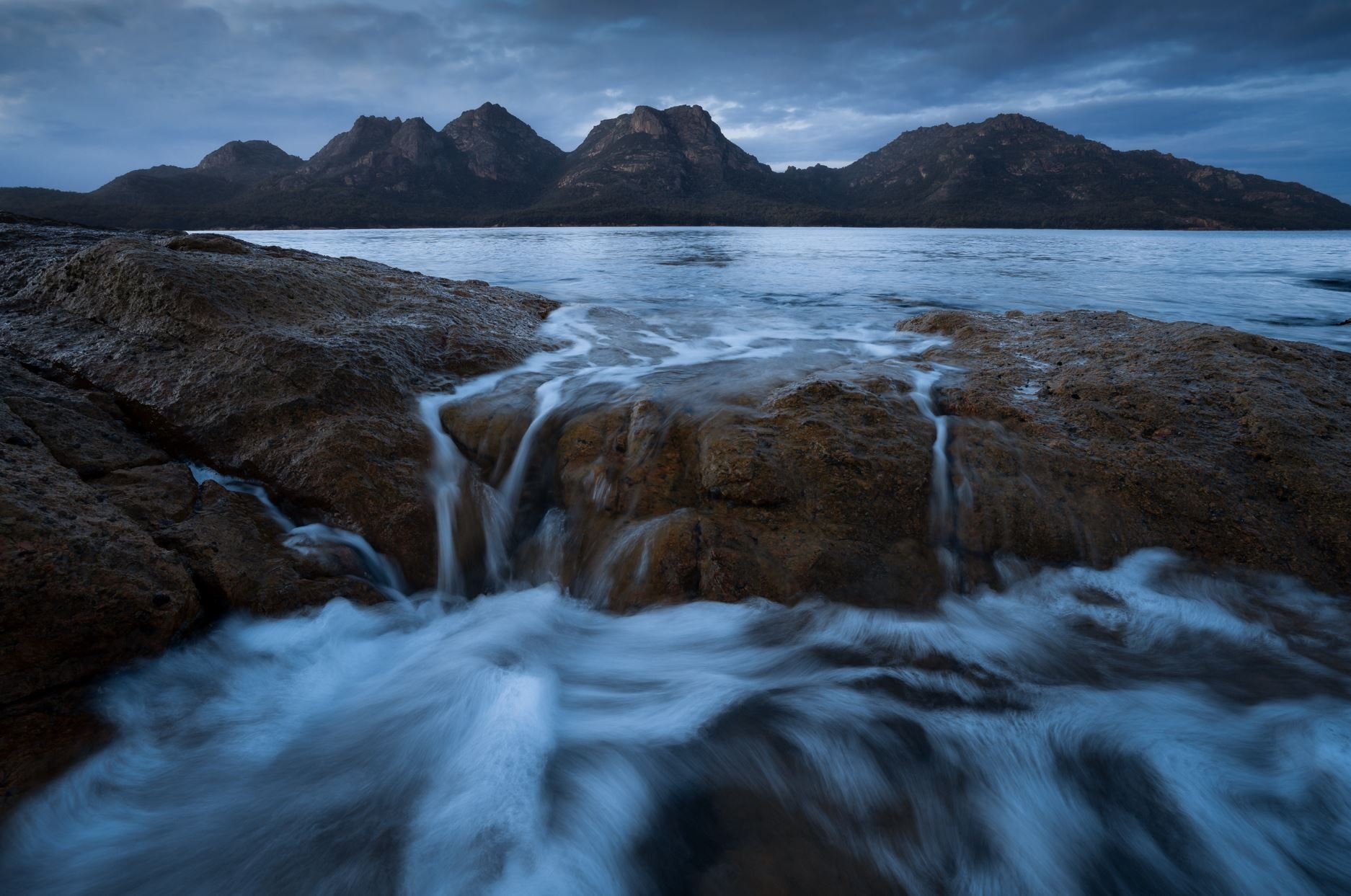 Moody landscape of The Hazards in Freycinet, Tasmania, showing jagged peaks and dramatic cloud cover