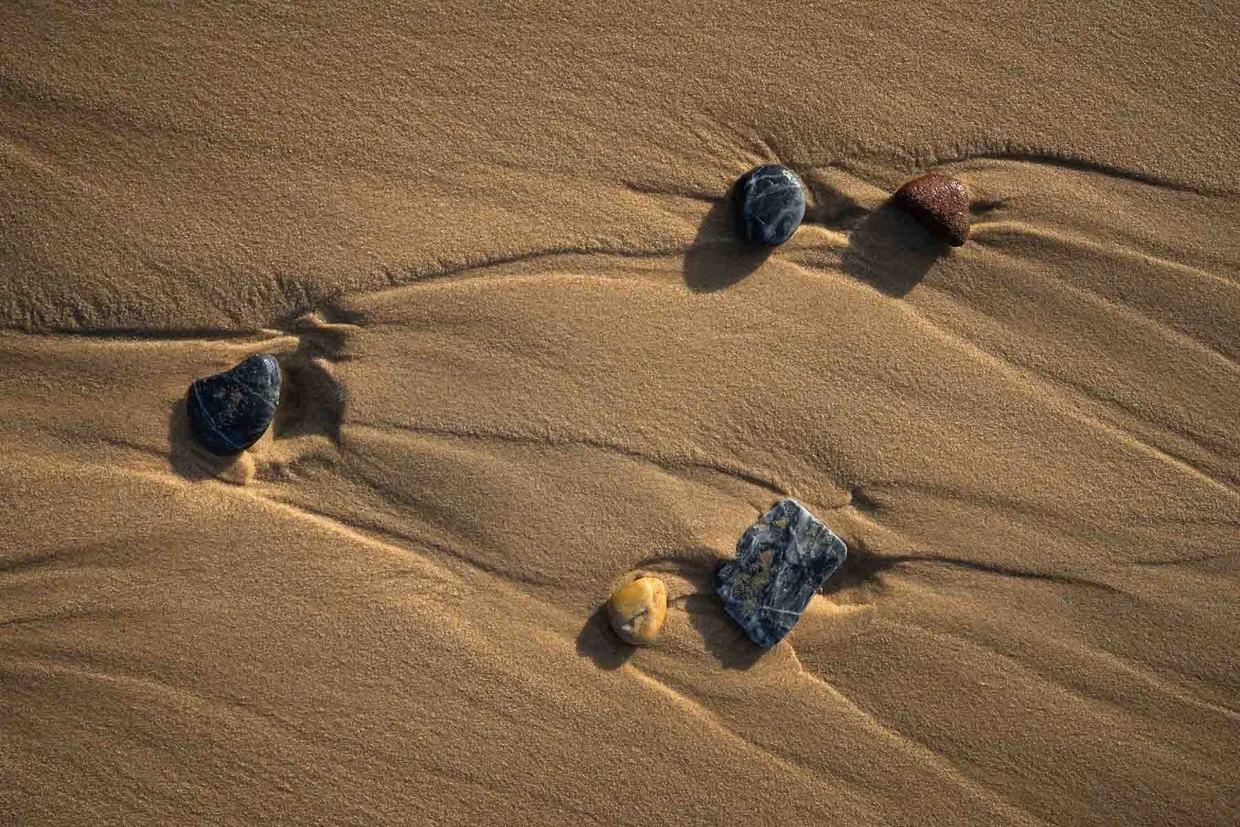Rocks surrounded by sand showing natural textures and patterns