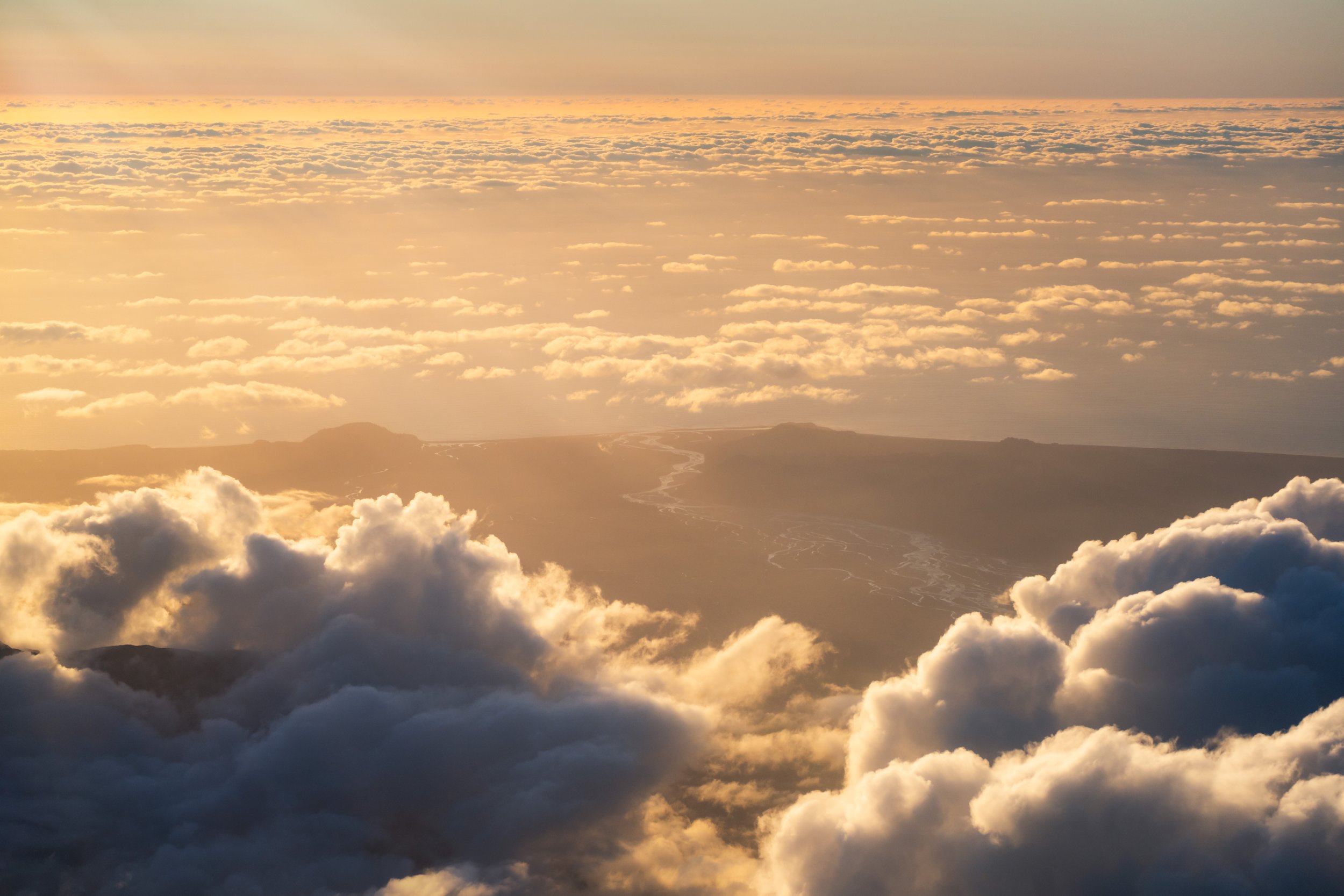 Breaking clouds revealing New Zealand’s coastline from above