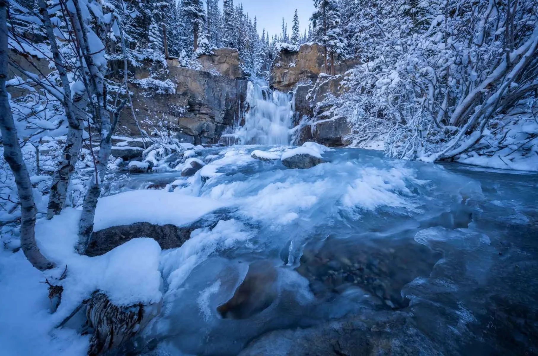Frozen waterfall surrounded by snow in Canada