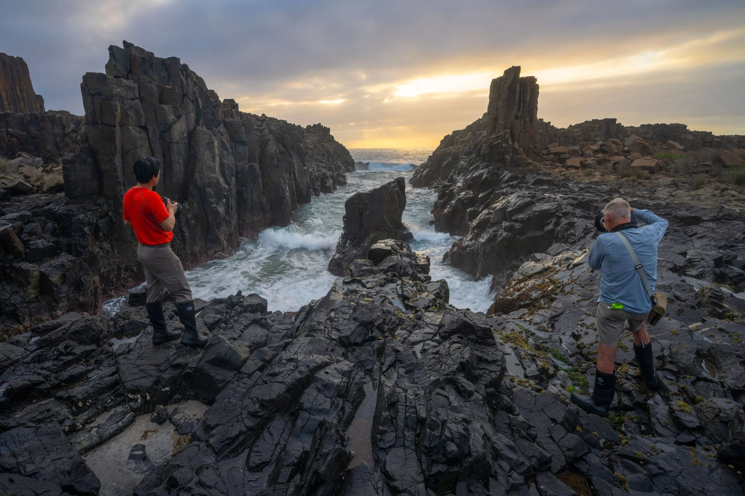 Photography workshop participants standing at Bombo Quarry at sunrise