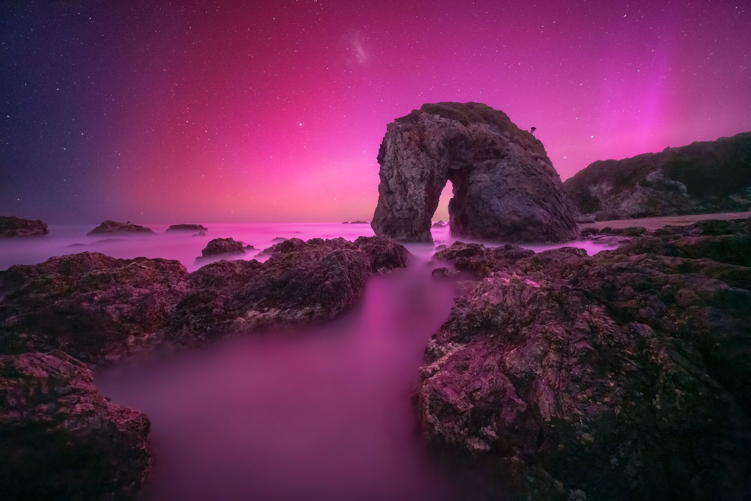 Southern lights illuminating the night sky above Horse Head Rock, Bermagui