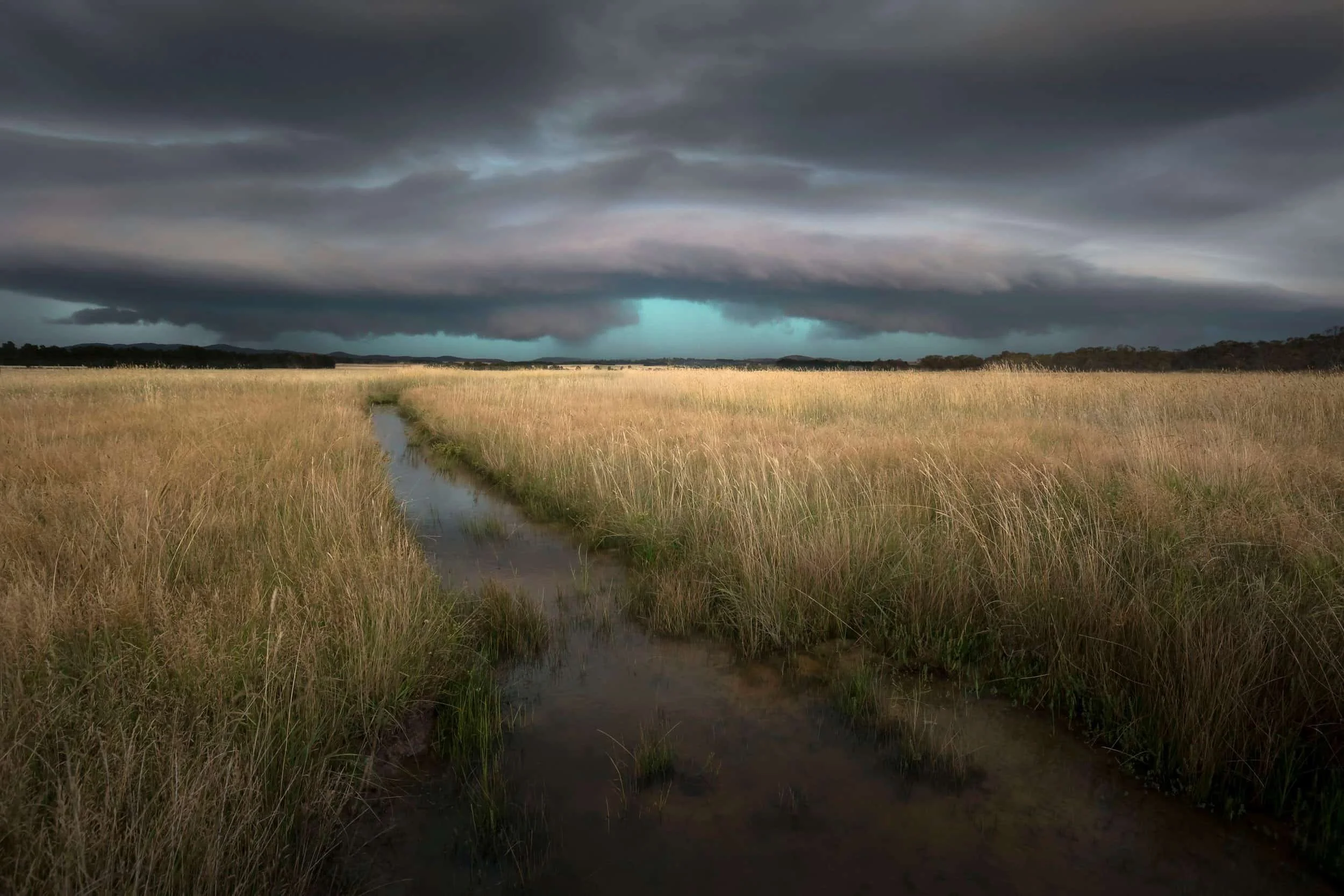 Thunderstorm approaching vast grasslands in rural New South Wales, with dramatic dark clouds