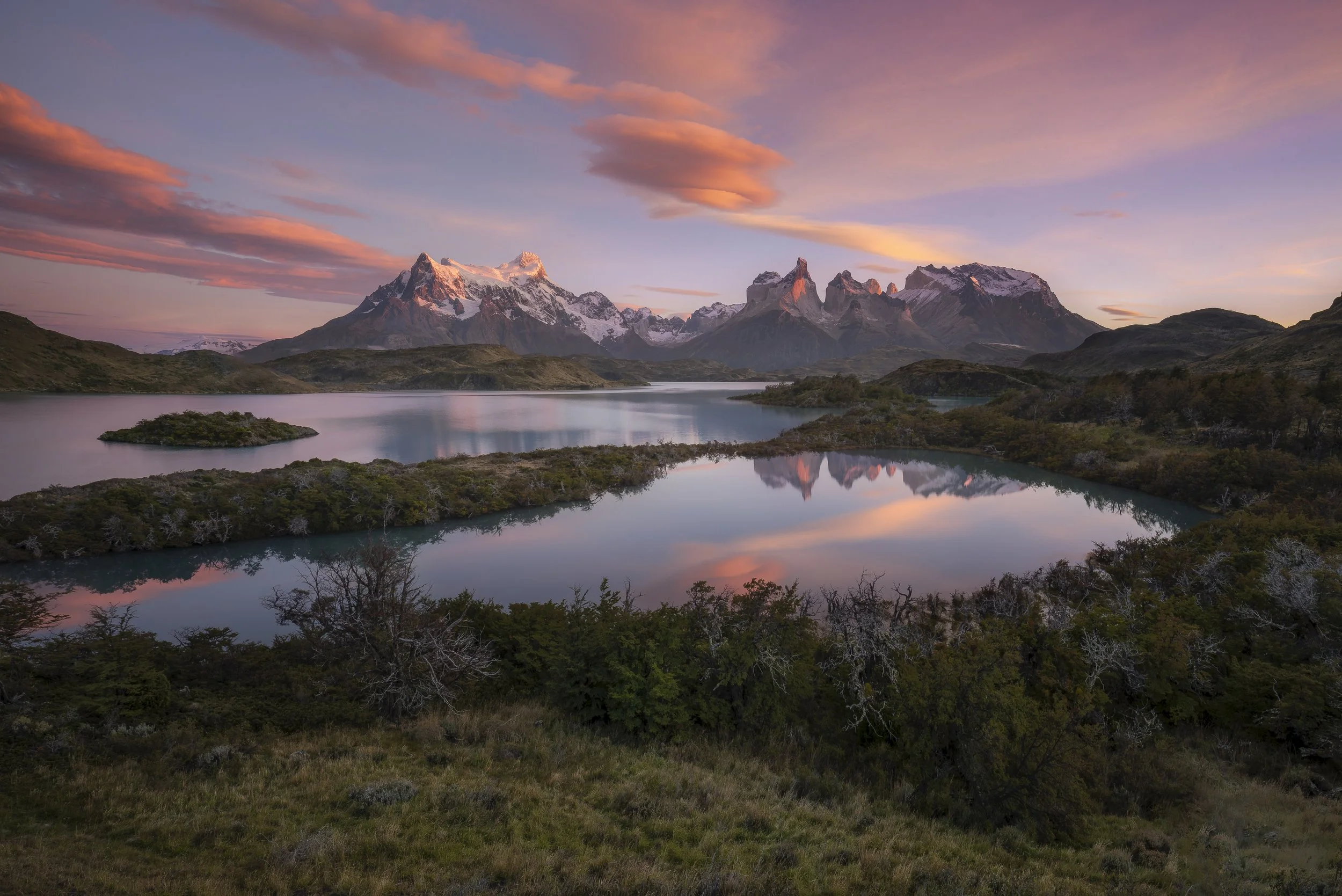 Sunrise over the peaks of Torres del Paine, casting warm light across the landscape