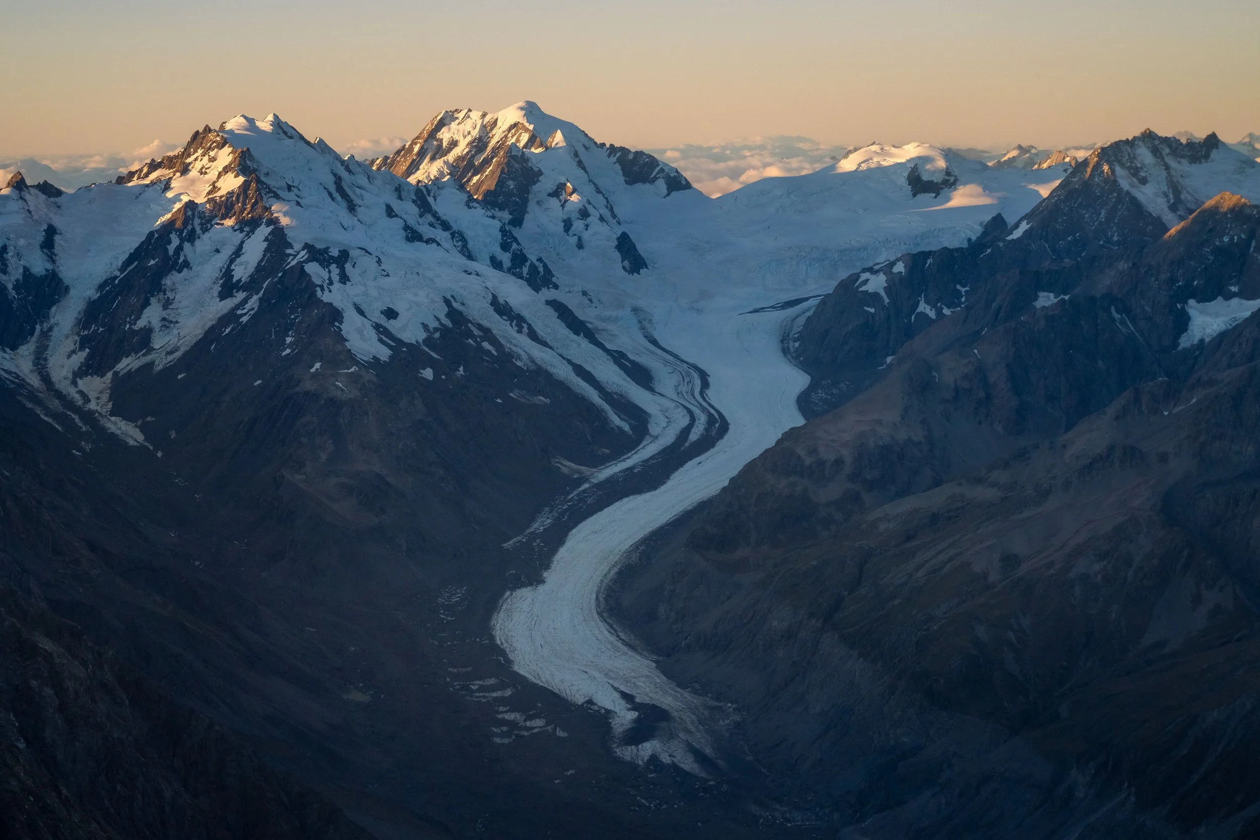 Tasman Glacier in New Zealand from above, highlighting the glacier’s flowing ice, crevasses, and nearby mountains
