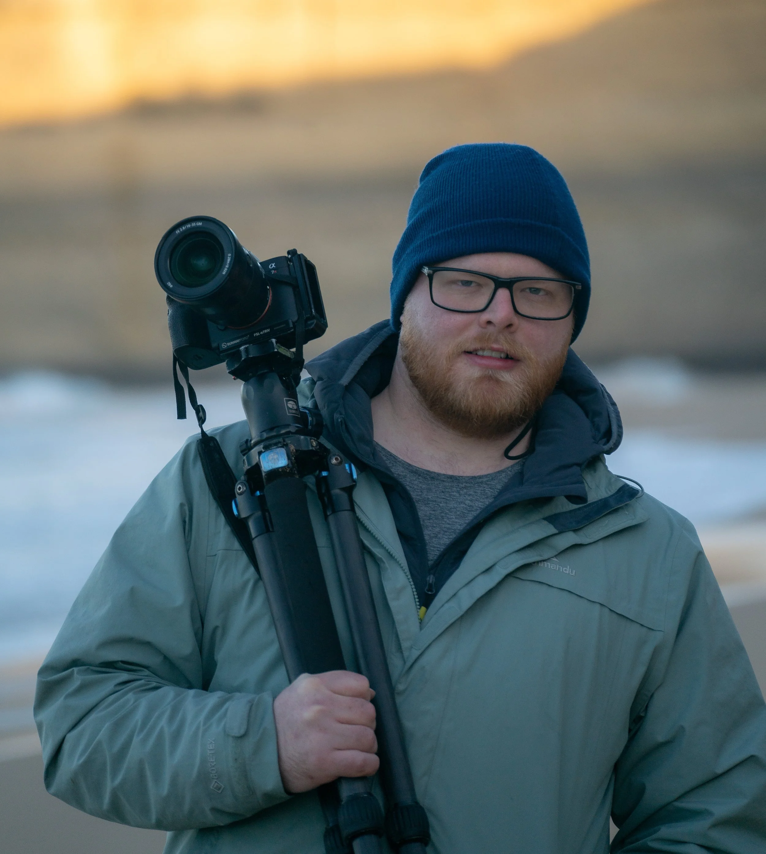 Image of Samuel Markham holding his camera and tripod