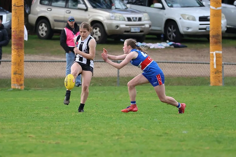 Catherine Coxen kicks out of defence as South's Alex French aims to spoil.JPG