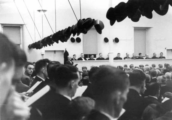 Harvest Home Service with John S. Hess of Lititz in 1938. Sam Detweiler is leading a song. Ministers and deacons seated in the pulpit include some visitors. Left to right: Abram Youthers, Alfred Detweiler, Wilson Overholt, Melvin Bishop, Enos Wismer (behind pole, John S. Hess, unidentified, Daniel Gahman, unidentified, Henry Delp, Franklin Aldefer and Harvery Meyers