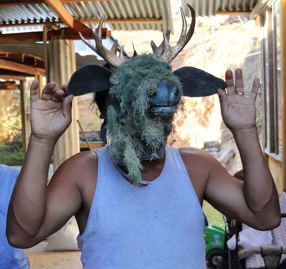 Don Ismael demonstrating the mask he wears for an annual community ceremony.