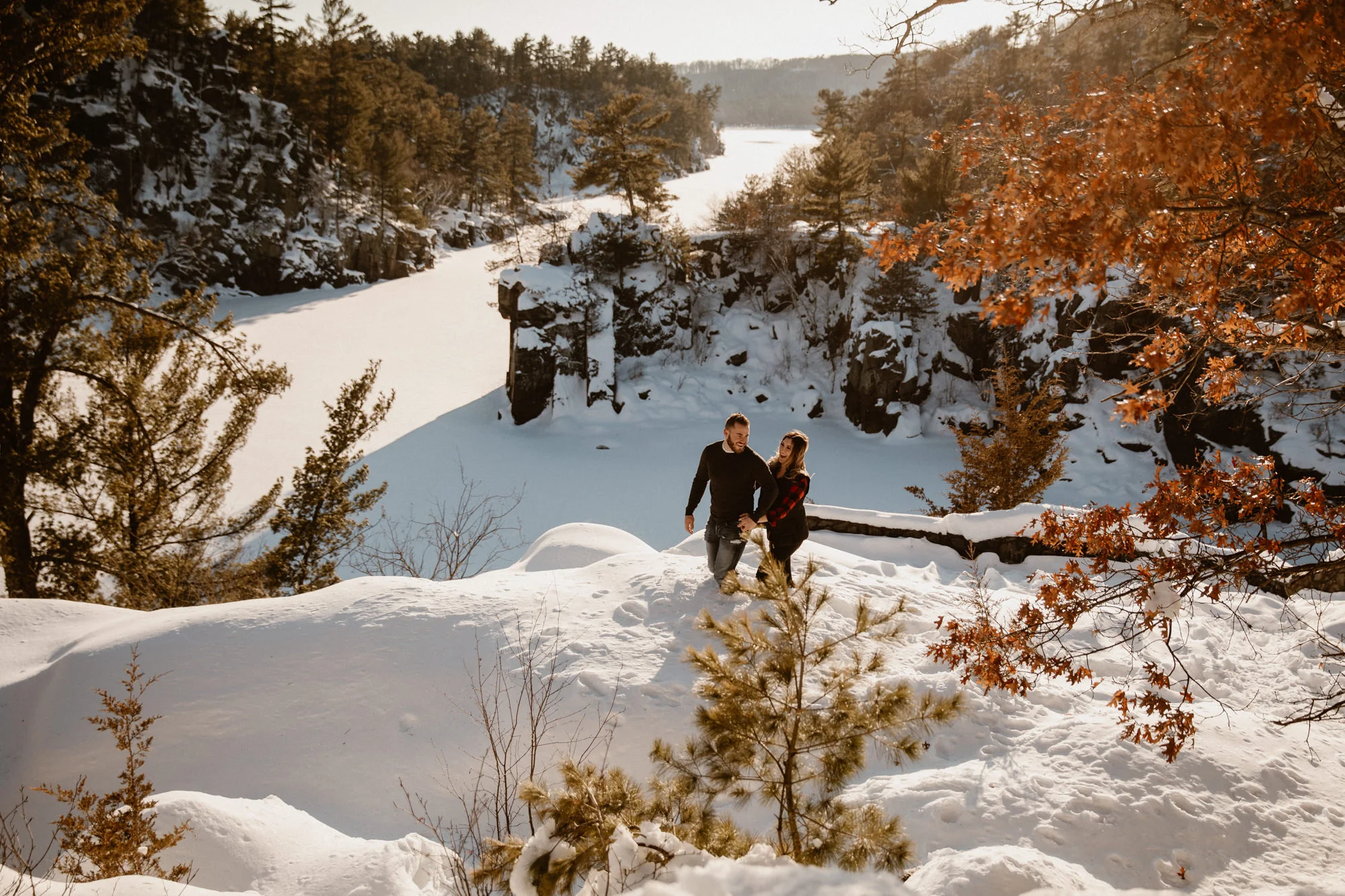 a couple hiking the epic landscape of the minnesota bluffs over the st. croix river.
