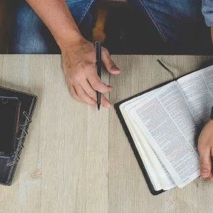 Table with Bible book and hand.jpg