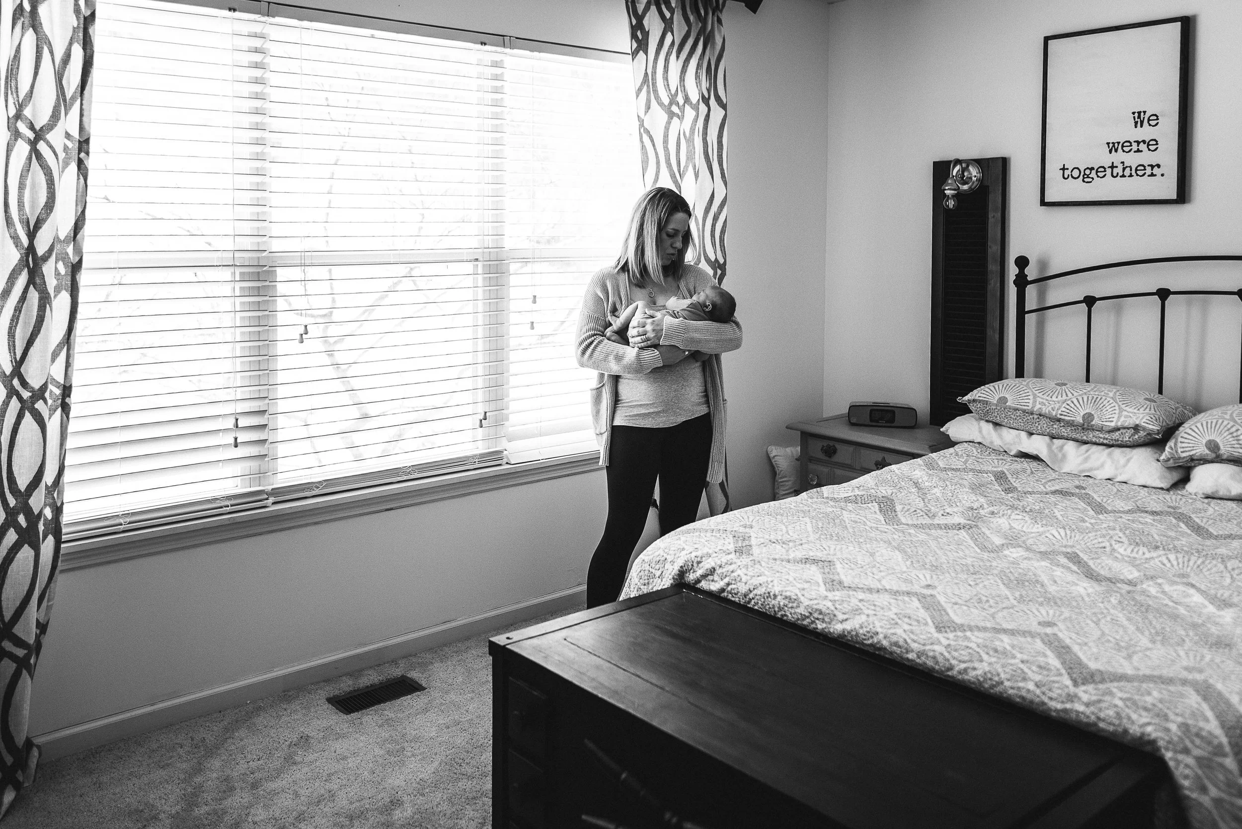 mom in bedroom holding baby