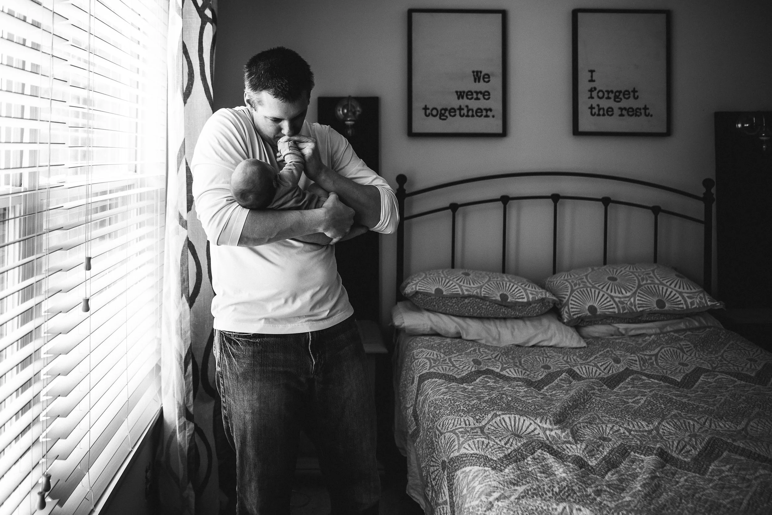 dad kissing new baby