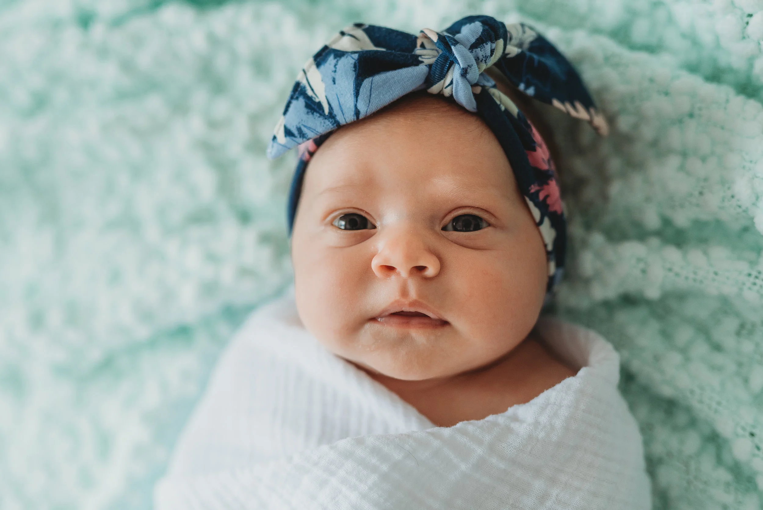 awake newborn on blanket