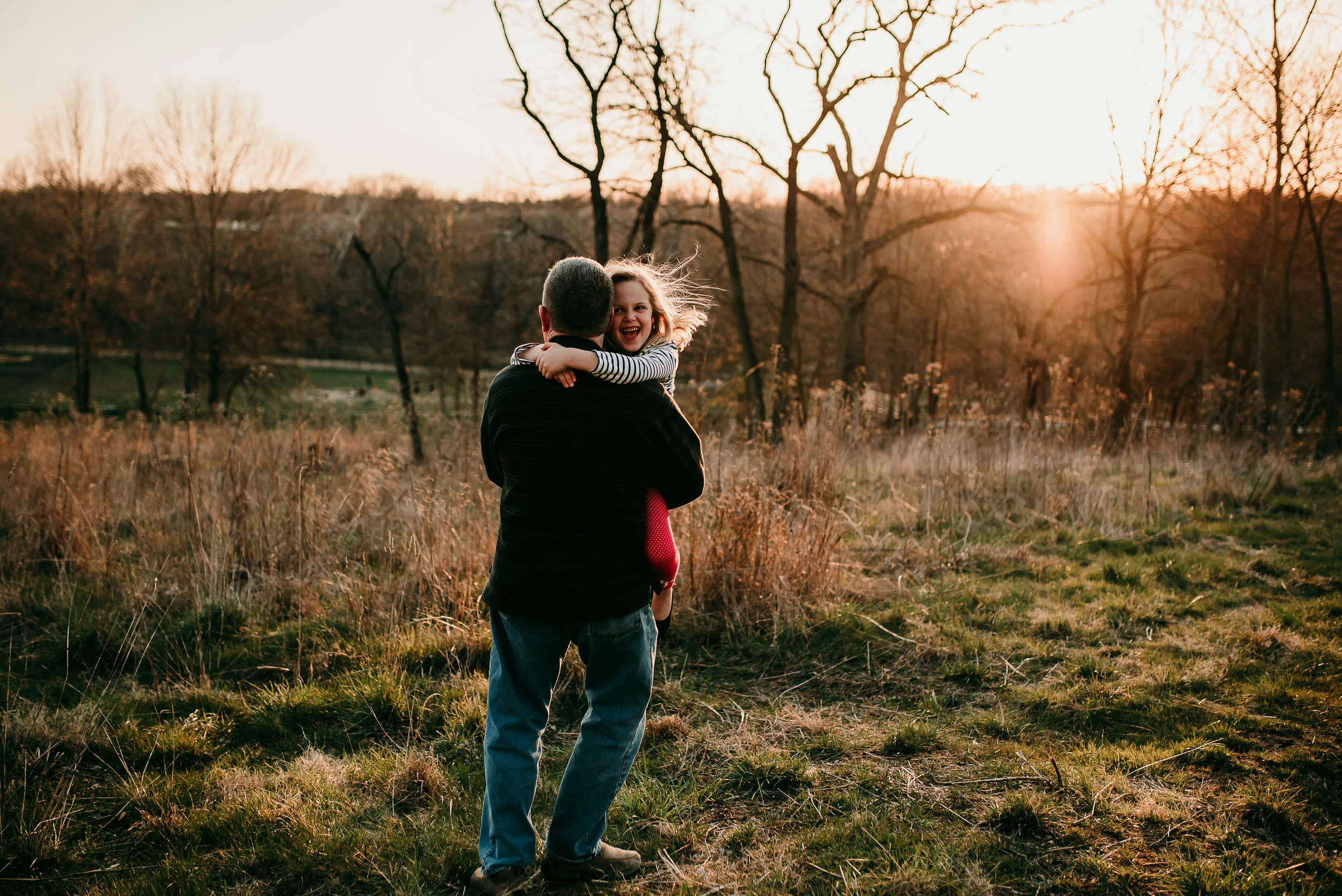 dad dancing with daughter in the sunset light