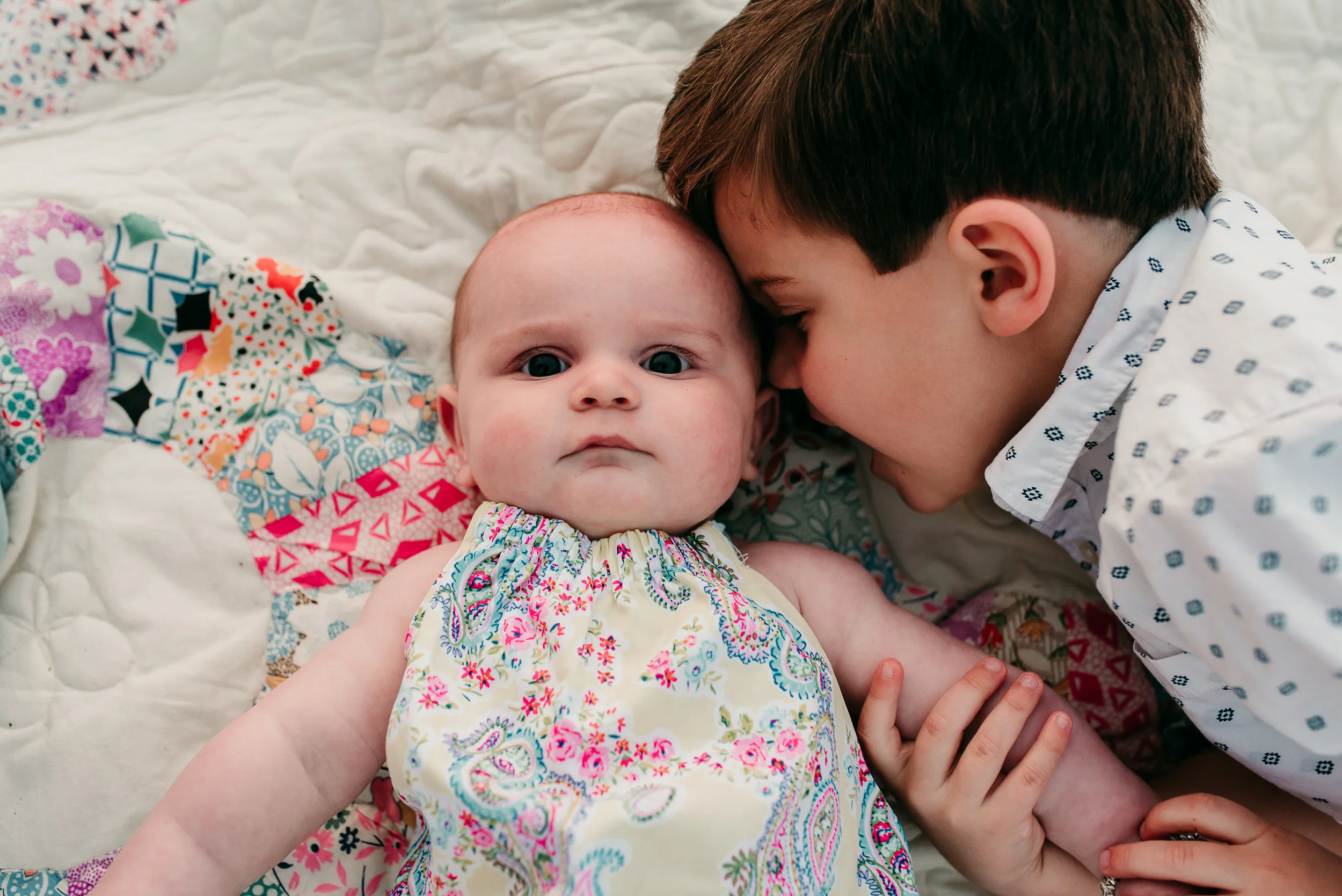 brother kissing baby sister