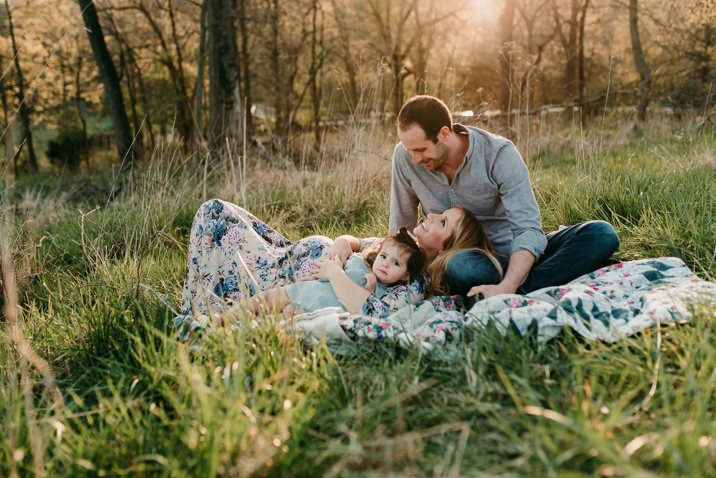 pregnant couple laying in field together