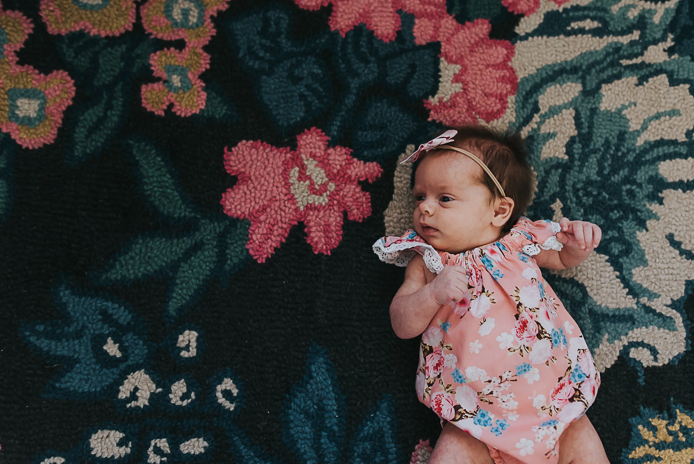 newborn baby girl on floral rug