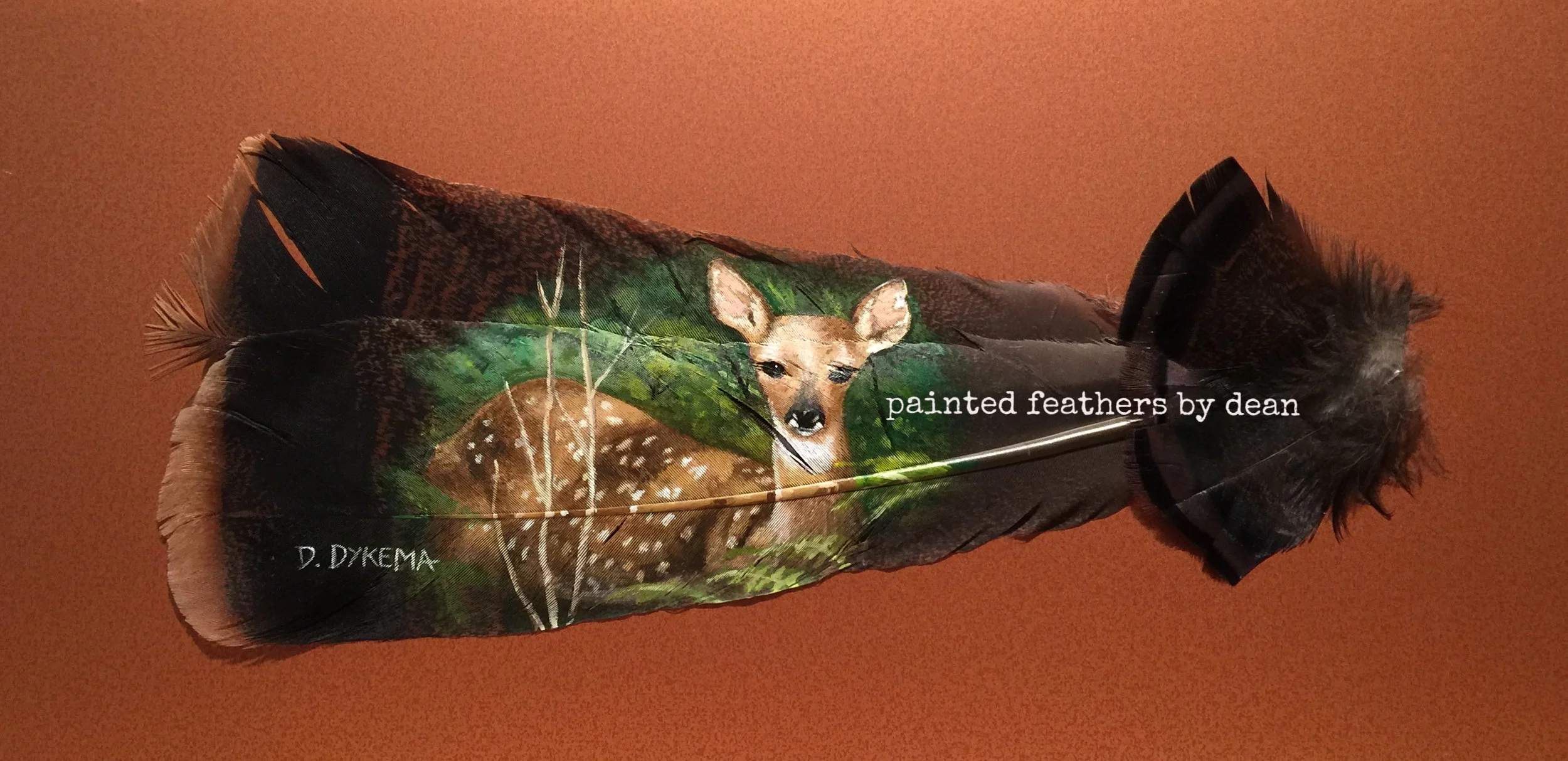  This Whitetail fawn lays hiding in the brush, waiting for mom to give the "all clear." The fawn is painted on two wild Eastern Turkey tail feathers. The base of the shafts are adorned with body feathers. The feathers are matted and framed in a shado
