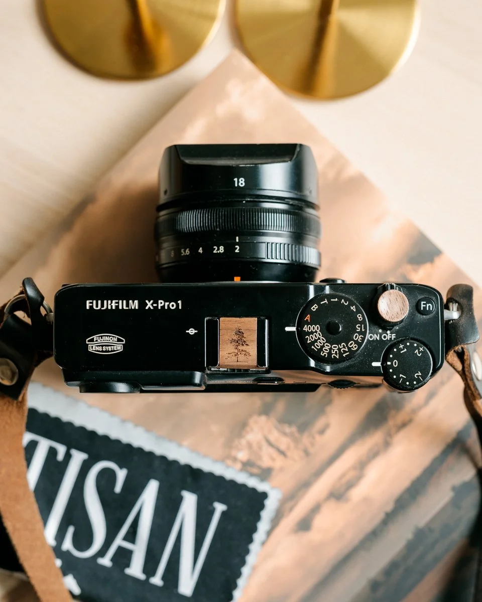 &ldquo;There are always two people in every picture: the photographer and the viewer.&rdquo;
&mdash; Ansel Adams

This Fuji X-Pro1 is outfitted with a spruce tree-engravedwalnut hot shoe cover and soft release button,  a symbol of stillness, strength