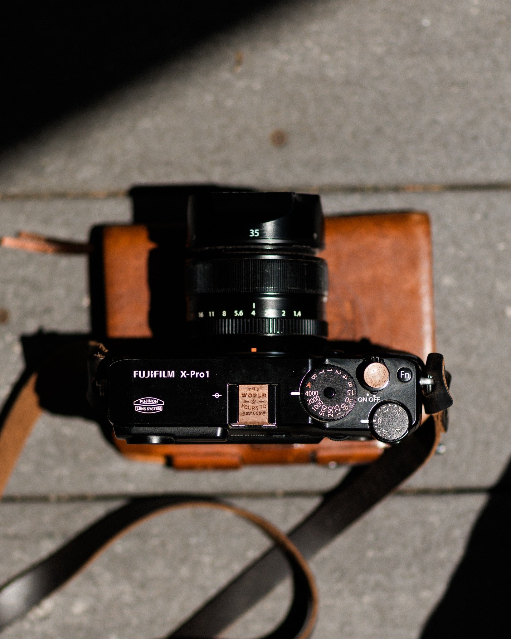 &ldquo;Photography is the only language that can be understood anywhere in the world.&rdquo;
&mdash; George Eastman

This Fuji X-Pro1 carries more than just a lens. Outfitted with a walnut &ldquo;The World is Yours to Explore&rdquo; engraved hot shoe