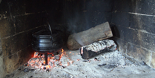 Let the coals do the work for you, place the item to be heated upon the coals, with a trivet if it is missing legs.