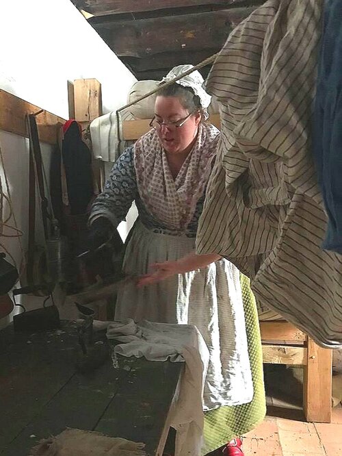 Here I am using my period mittens so that I can hold the hot iron. Image courtesy of Kathryn Weller, 34th RoF