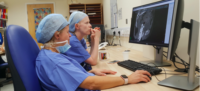 Figure 2 – Dr Alexandra and myself planning a patient’s brachytherapy treatment. The equipment has been inserted in theatre, the patient has had a CT scan and we are drawing the tumour that we want to treat and the normal tissue that we want to avoid.